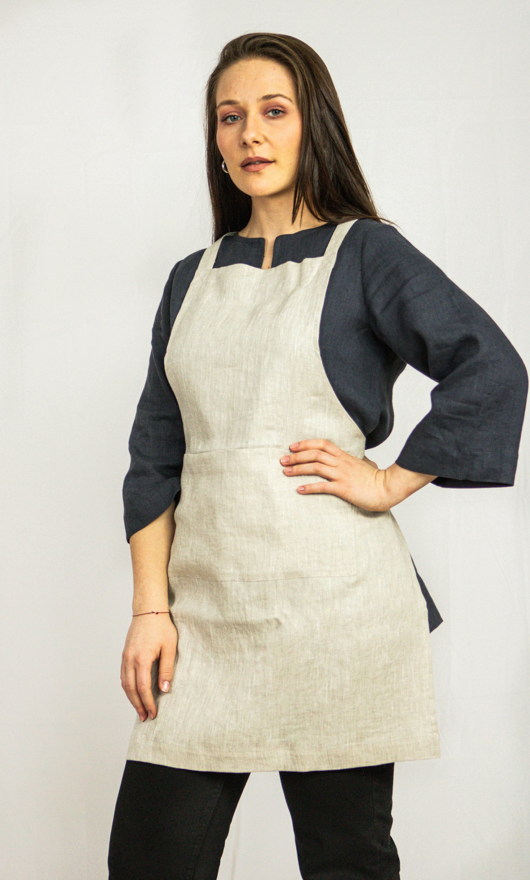 Moss Green linen apron with adjustable back ties and front pockets, showcasing its elegant design and functionality.