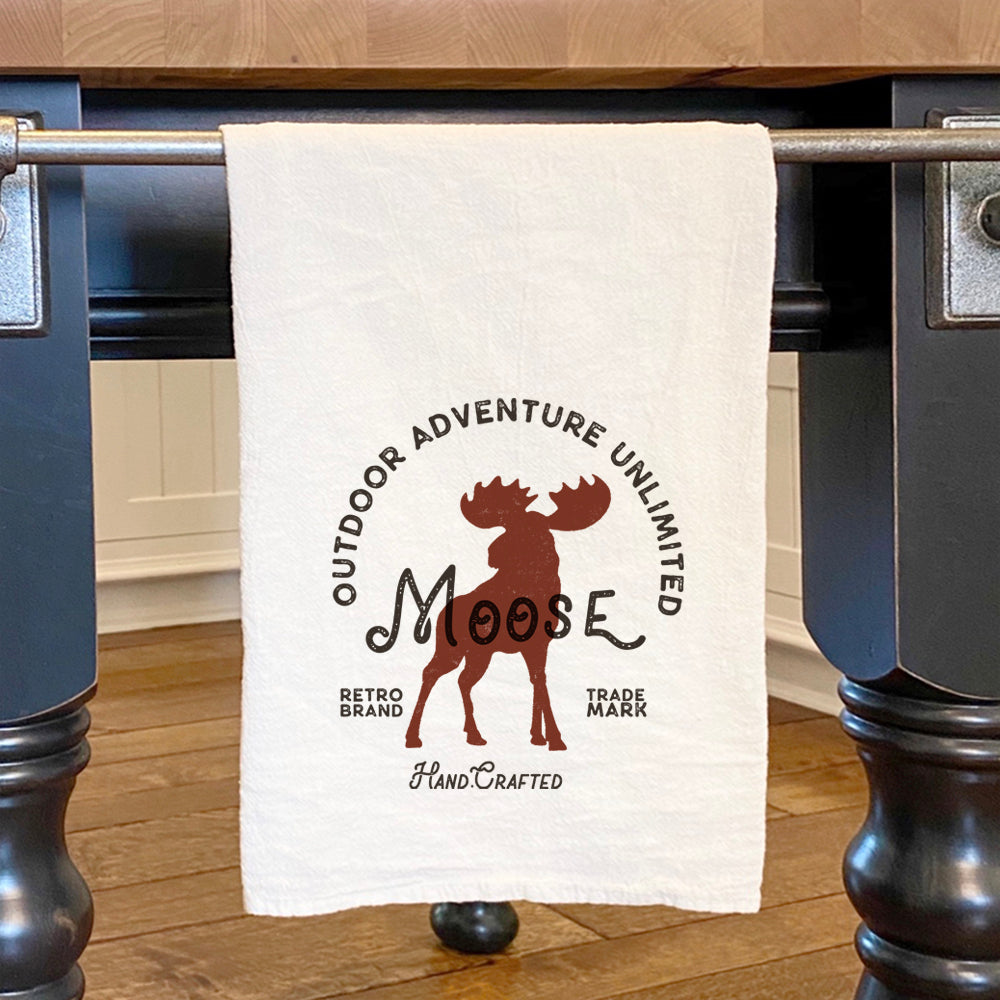 Moose Badge Cotton Tea Towel featuring vibrant design and hemmed edges, perfect for kitchen use.