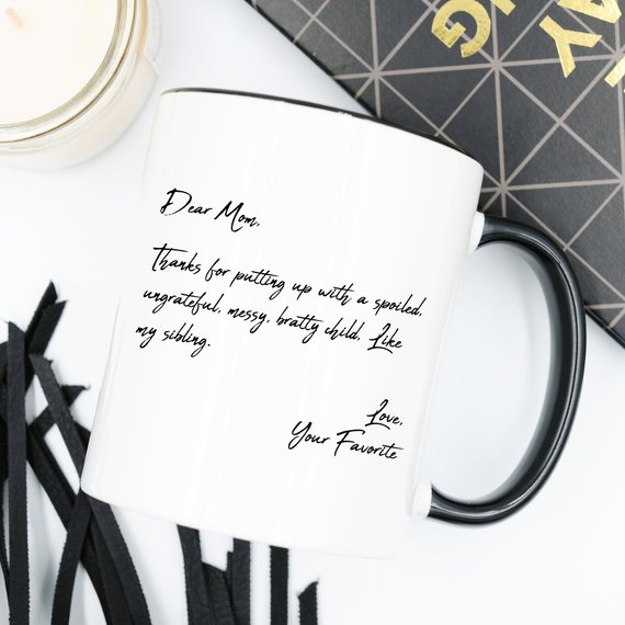 A humorous coffee mug with the text 'Dear Mom, Thanks 4 Putting Up With A S, Your Favorite', featuring a stylish design and a comfortable handle.