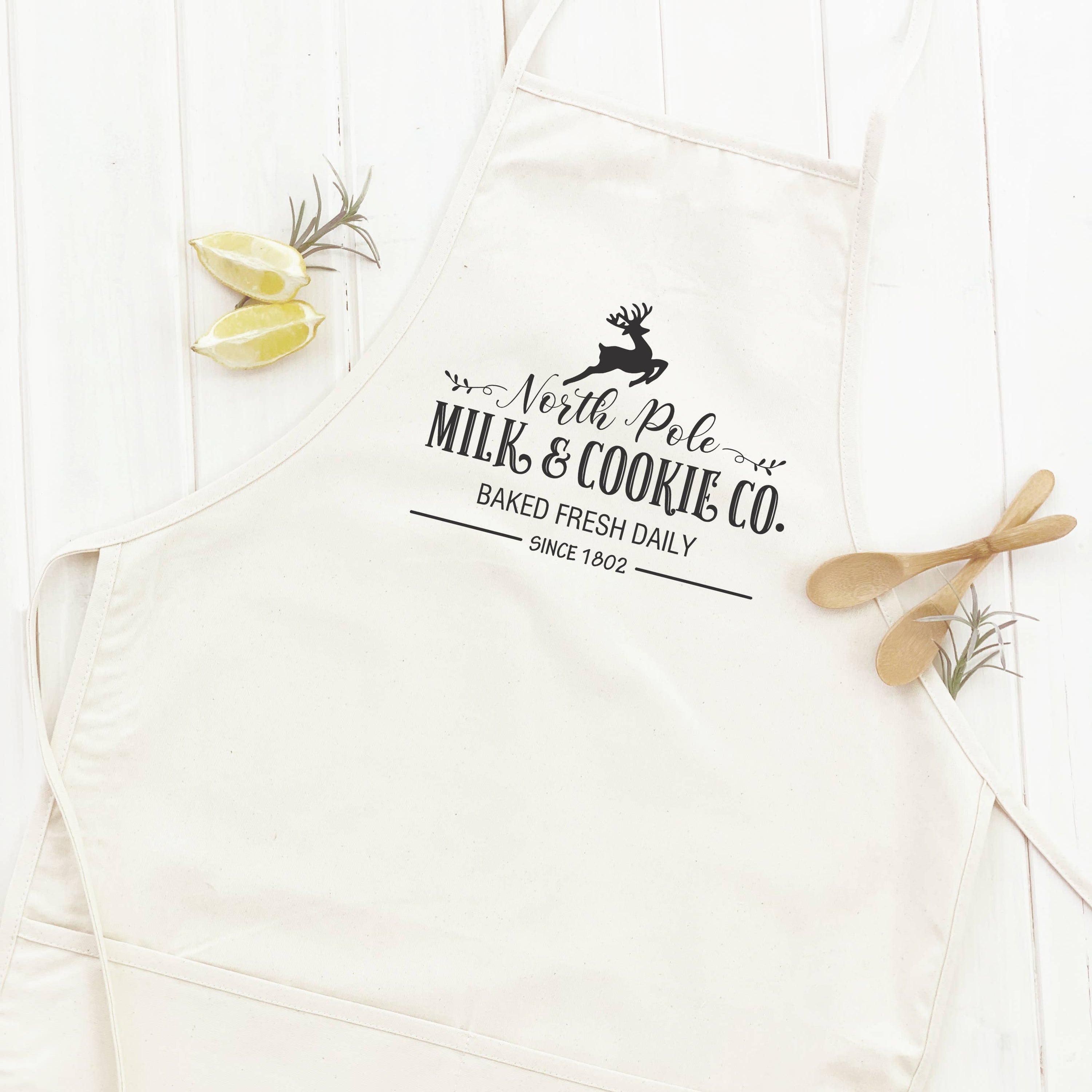 North Pole Milk & Cookies Women's Apron featuring elegant design, adjustable neck, and divided front pocket, made from durable cotton canvas.