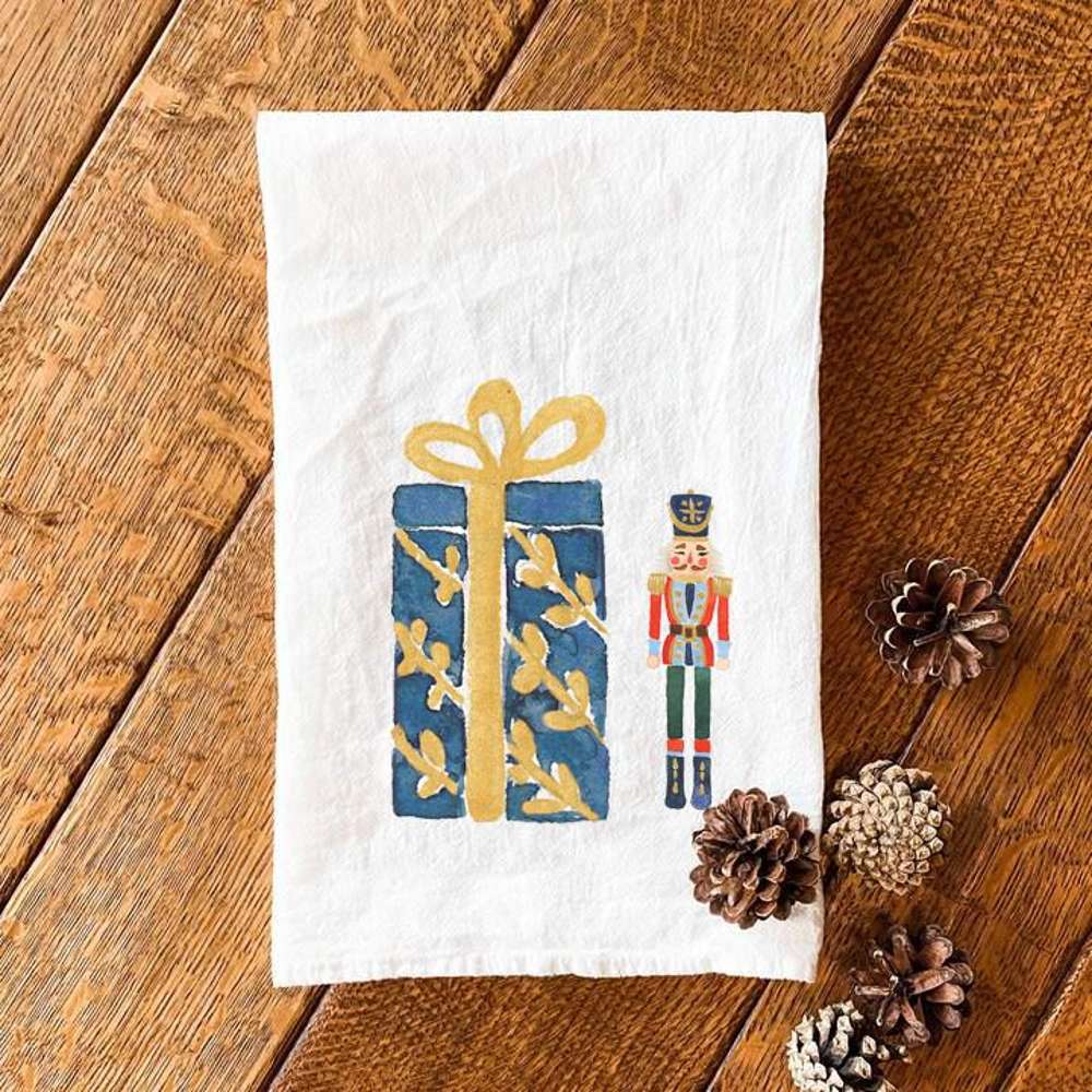 Nutcracker and Present cotton tea towel featuring vibrant colors and festive design, perfect for kitchen use.