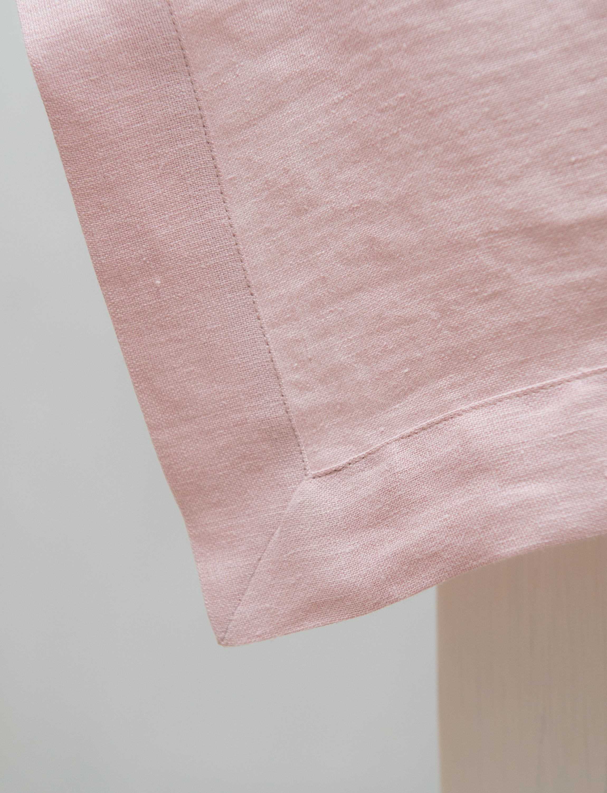 Pale Pink linen tablecloth draped elegantly over a dining table, showcasing its soft texture and luxurious appearance.