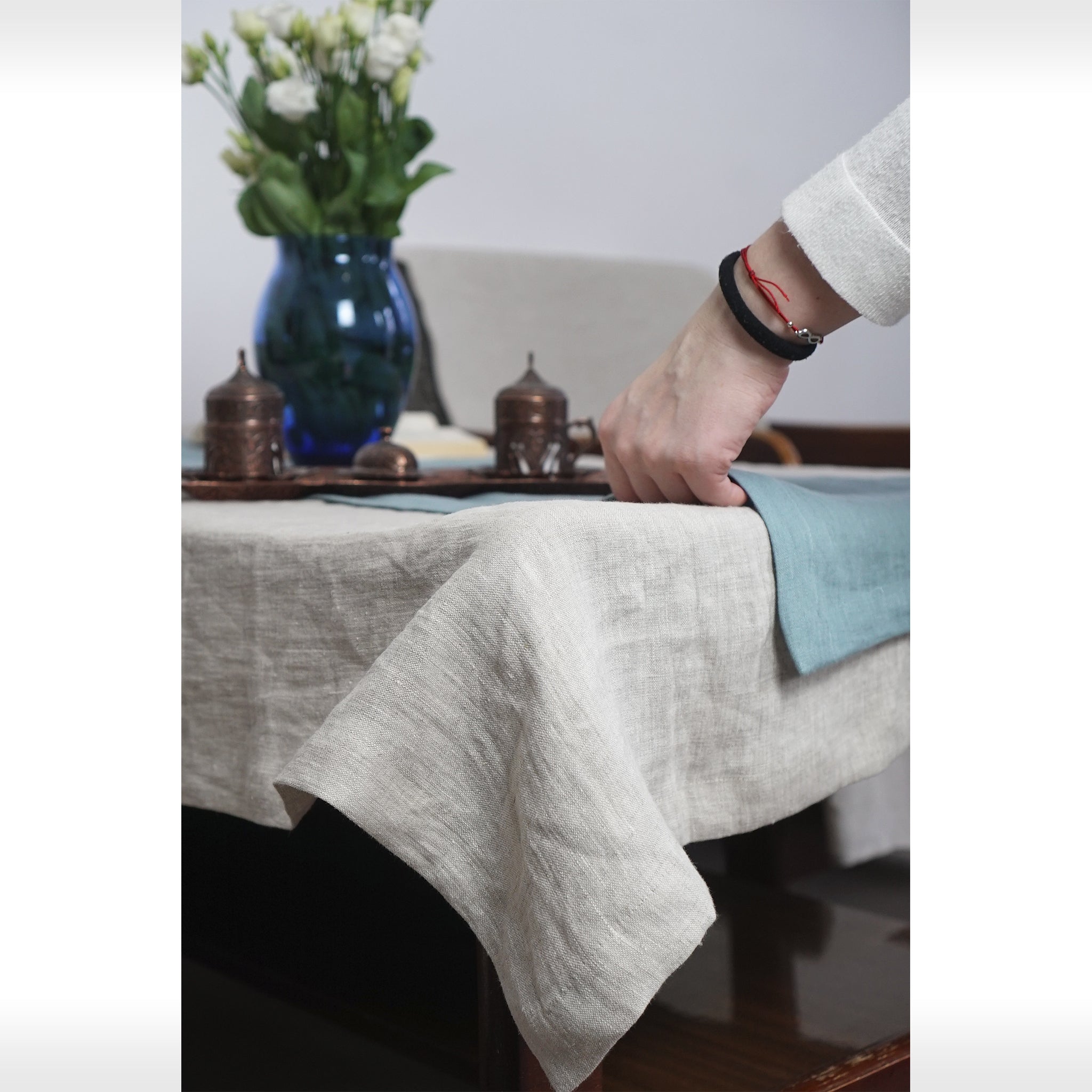 Pale Pink linen tablecloth draped elegantly over a dining table, showcasing its soft texture and luxurious appearance.