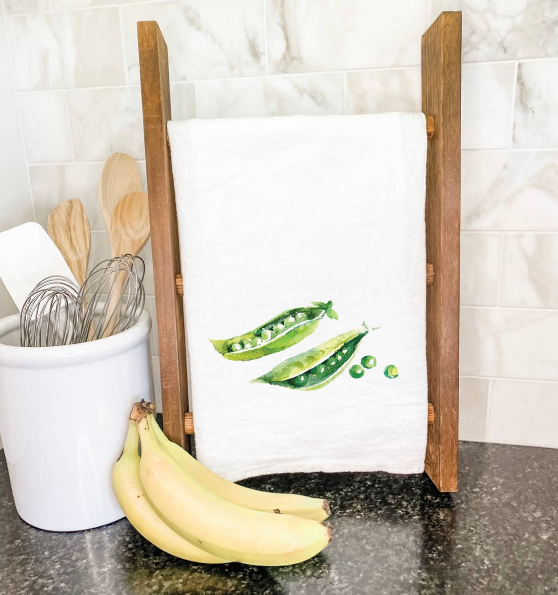 A vibrant Peas Cotton Tea Towel featuring a charming pea design, made from 100% absorbent cotton, perfect for kitchen use.