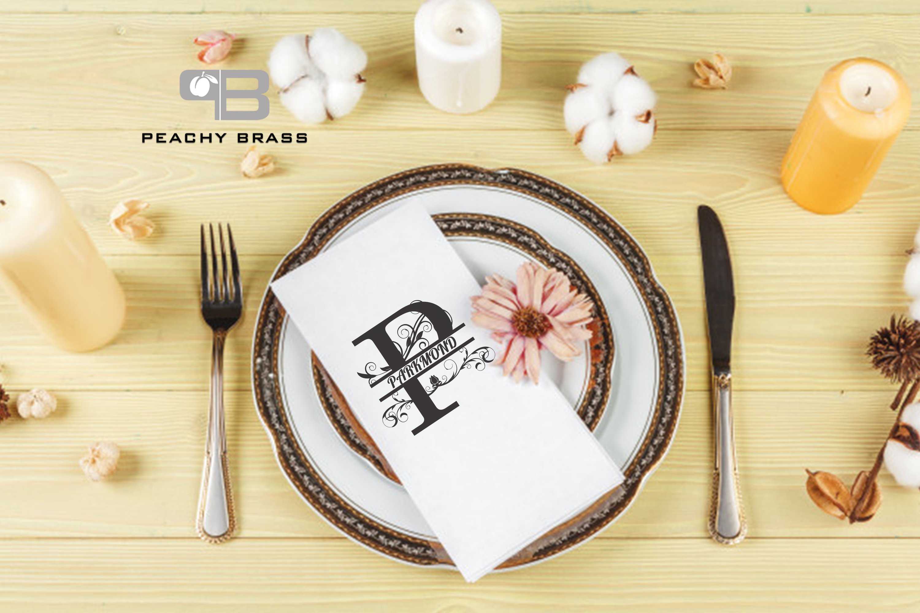 Set of six personalized cloth napkins in white with black initials, elegantly folded on a dining table.