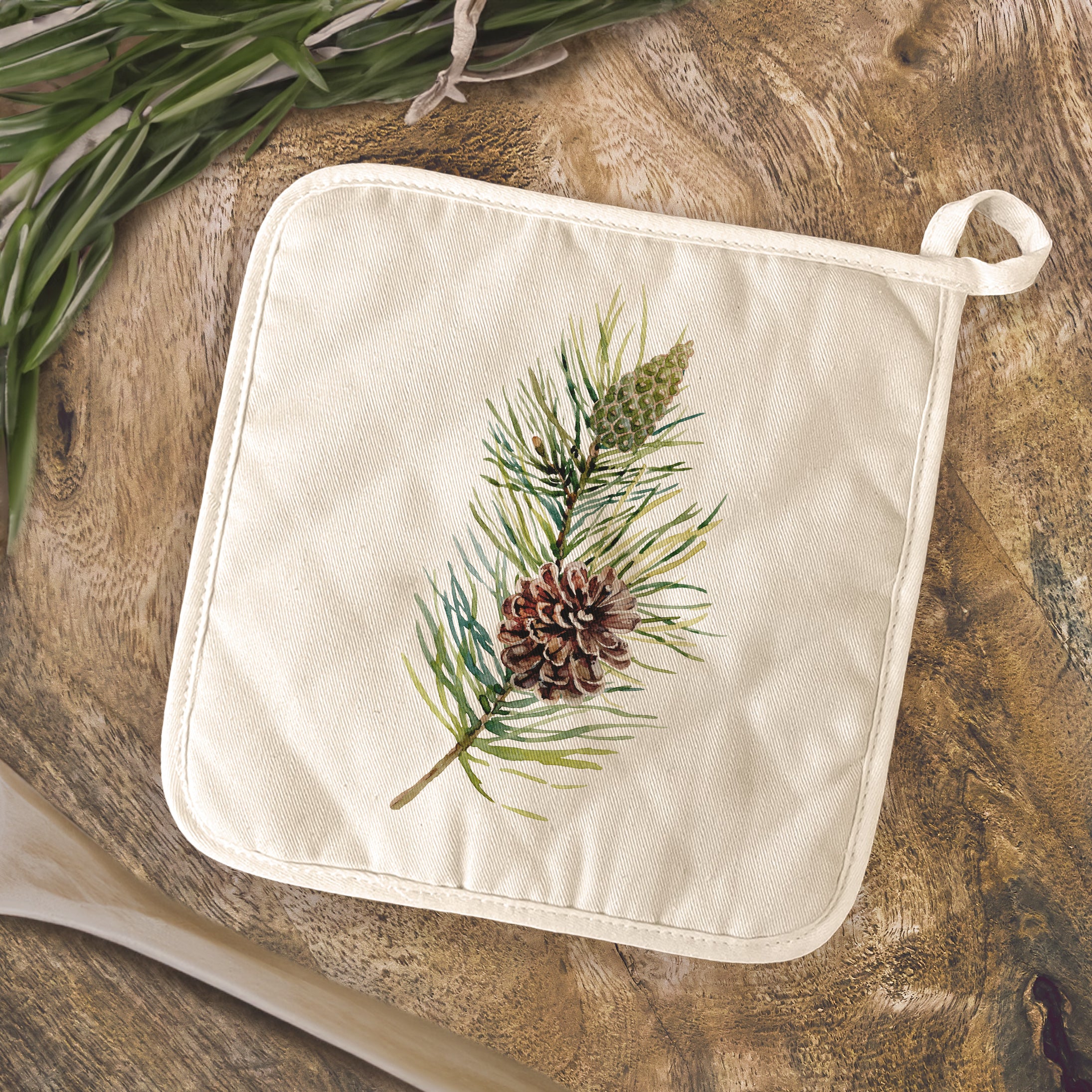 Pine Branch Cotton Pot Holder featuring vibrant designs and a convenient hanging loop, perfect for protecting surfaces from hot cookware.