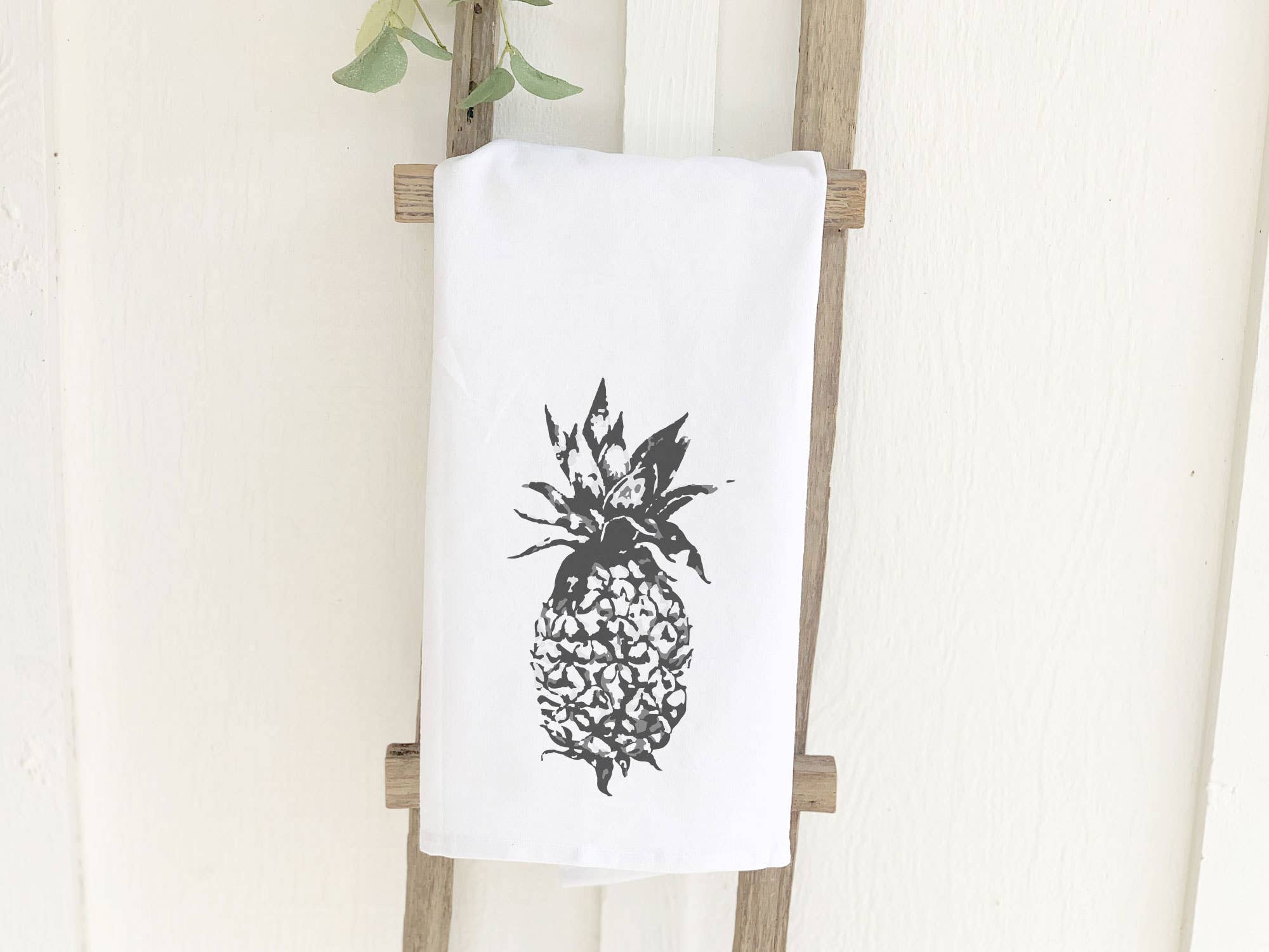 A vibrant pineapple design on a 100% cotton tea towel, showcasing its absorbent texture and hemmed edges.