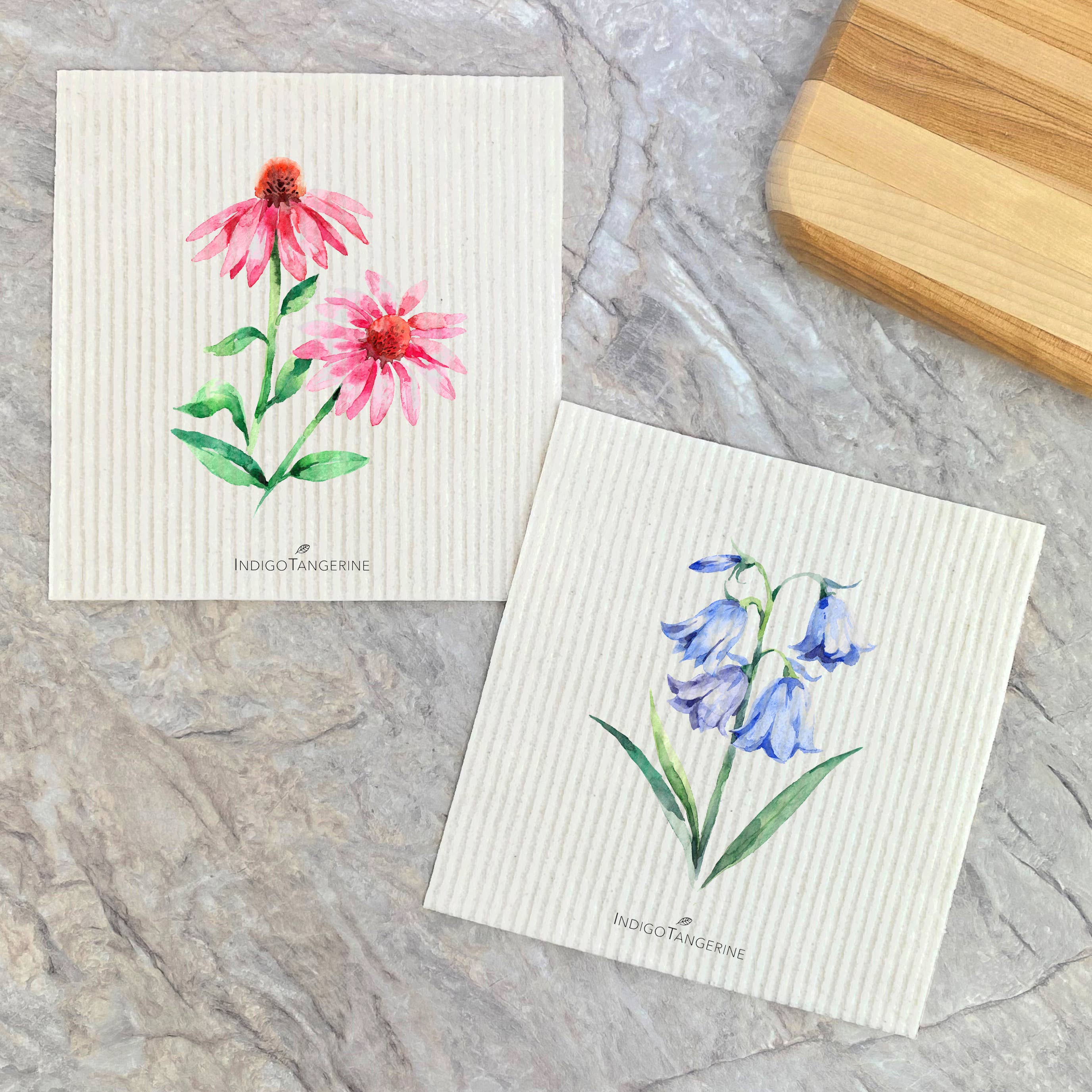 Two Swedish dish cloths featuring Pink Coneflower and Bluebells designs, eco-friendly and reusable.