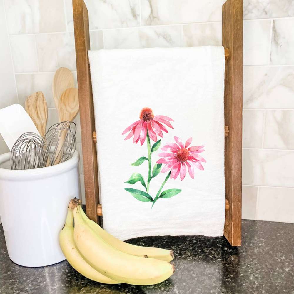 A vibrant pink coneflower design on a cotton tea towel, showcasing its absorbent texture and hemmed edges.