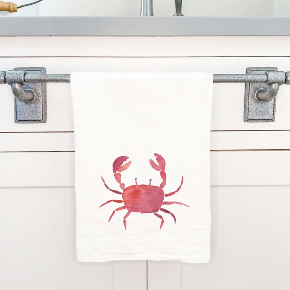 A vibrant red crab design on a 100% cotton tea towel, showcasing its absorbent texture and hemmed edges.