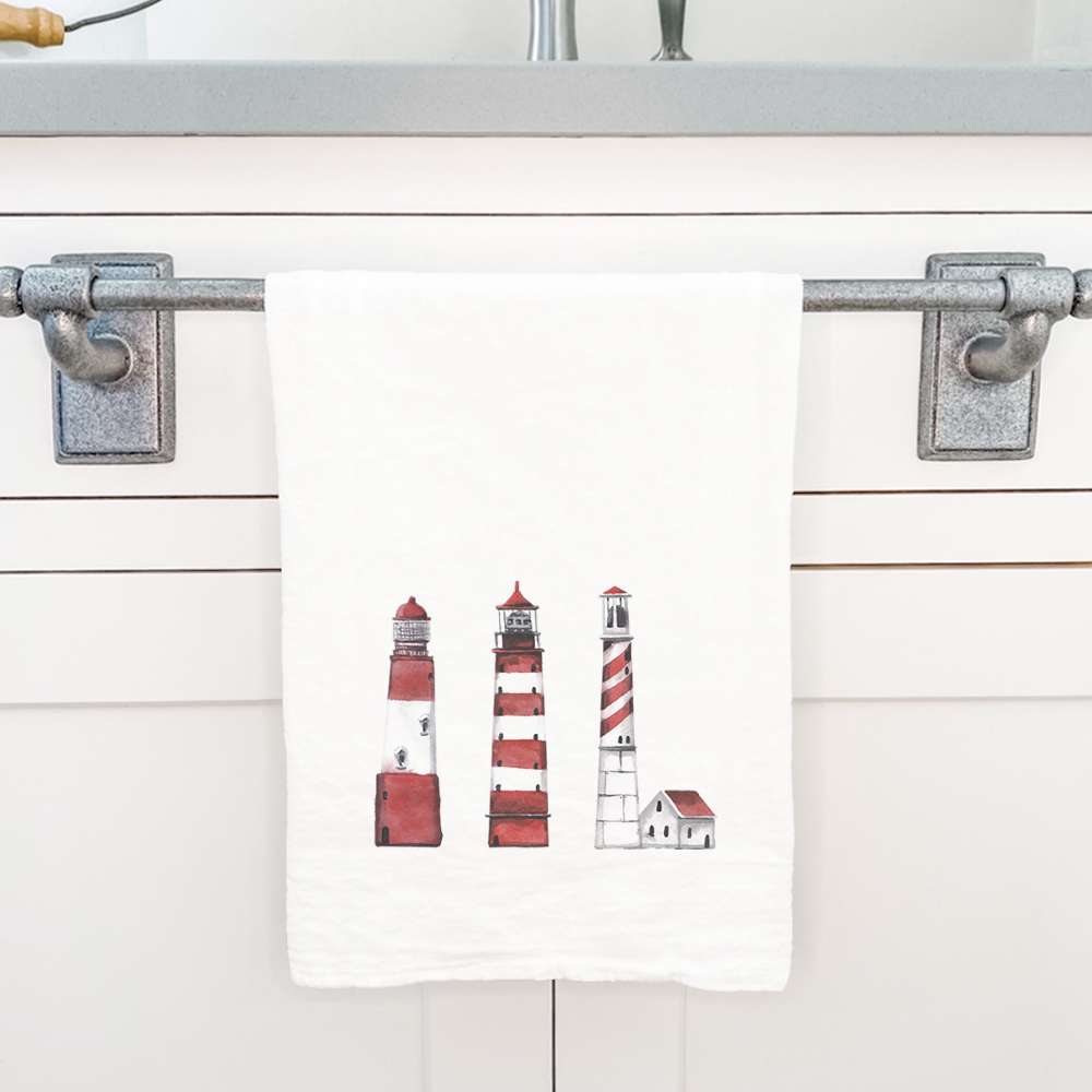 A vibrant red cotton tea towel featuring a lighthouse design, perfect for kitchen use and decorative purposes.