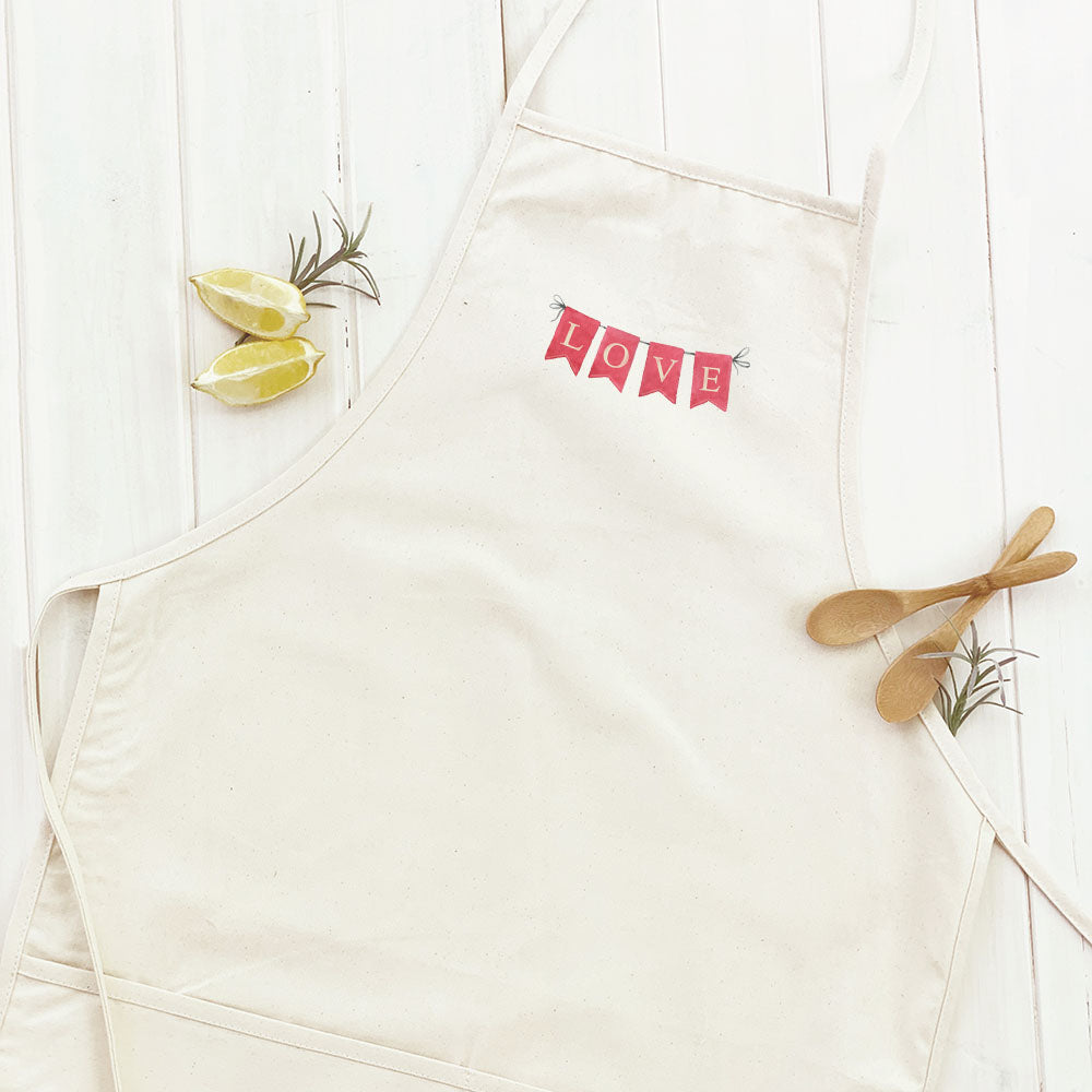 Red Love Banner Women's Apron featuring elegant design, adjustable neck, and divided front pocket, made from durable cotton canvas.