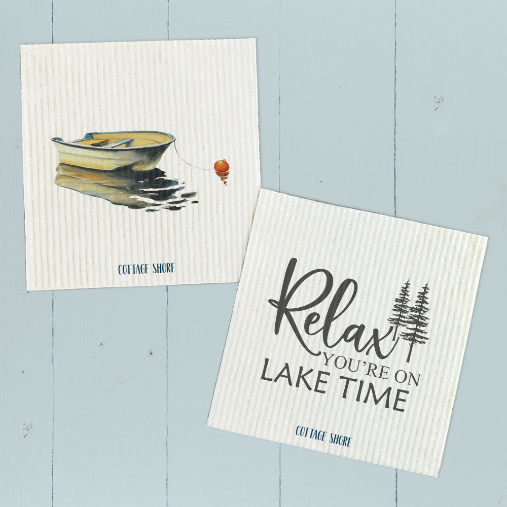 Two Swedish dishcloths featuring a lake-themed design with a rowboat, made from eco-friendly materials.