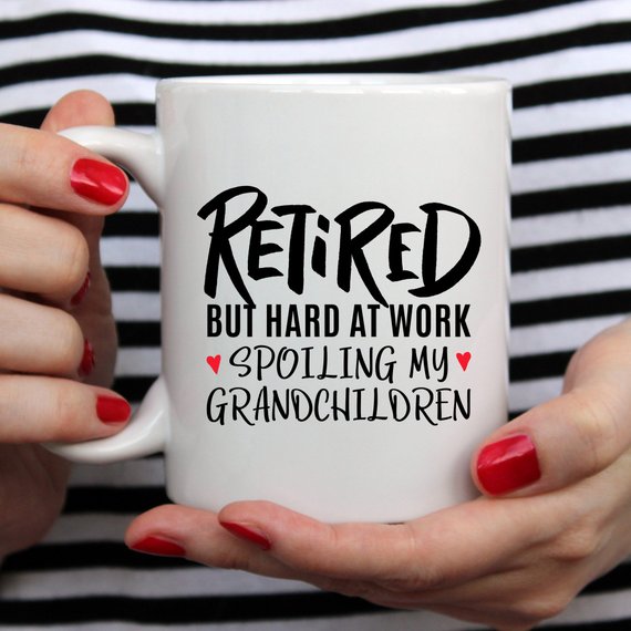 A humorous coffee mug with the phrase 'Retired But Hard At Work Spoiling My Grandchildren', showcasing a playful design perfect for grandparents.