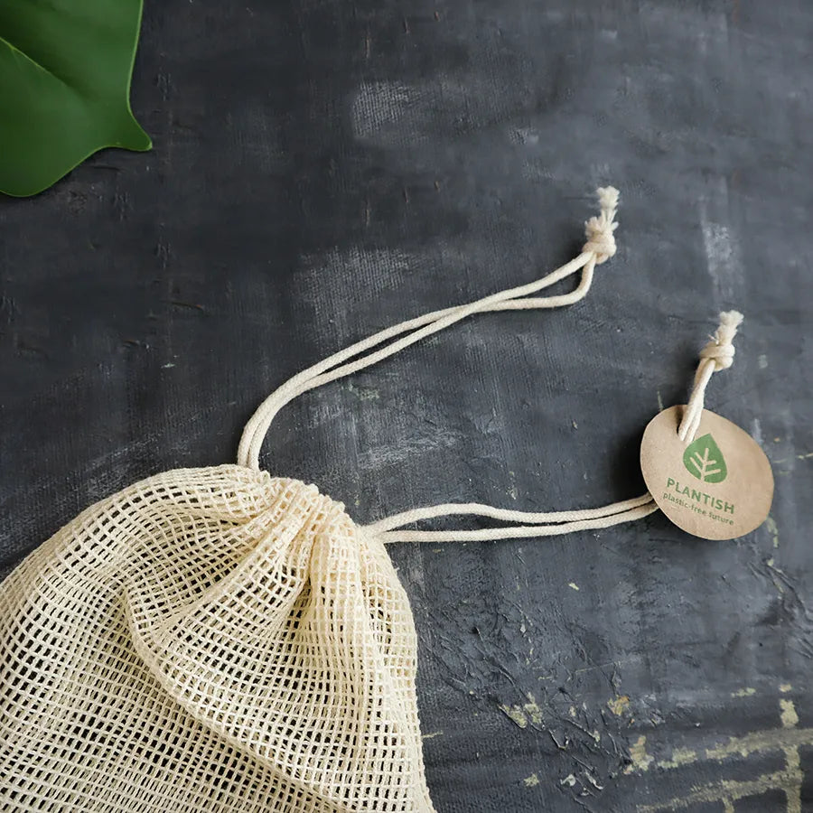 A set of reusable cotton rounds made from cotton and bamboo, displayed in an organic mesh bag, showcasing their eco-friendly design.