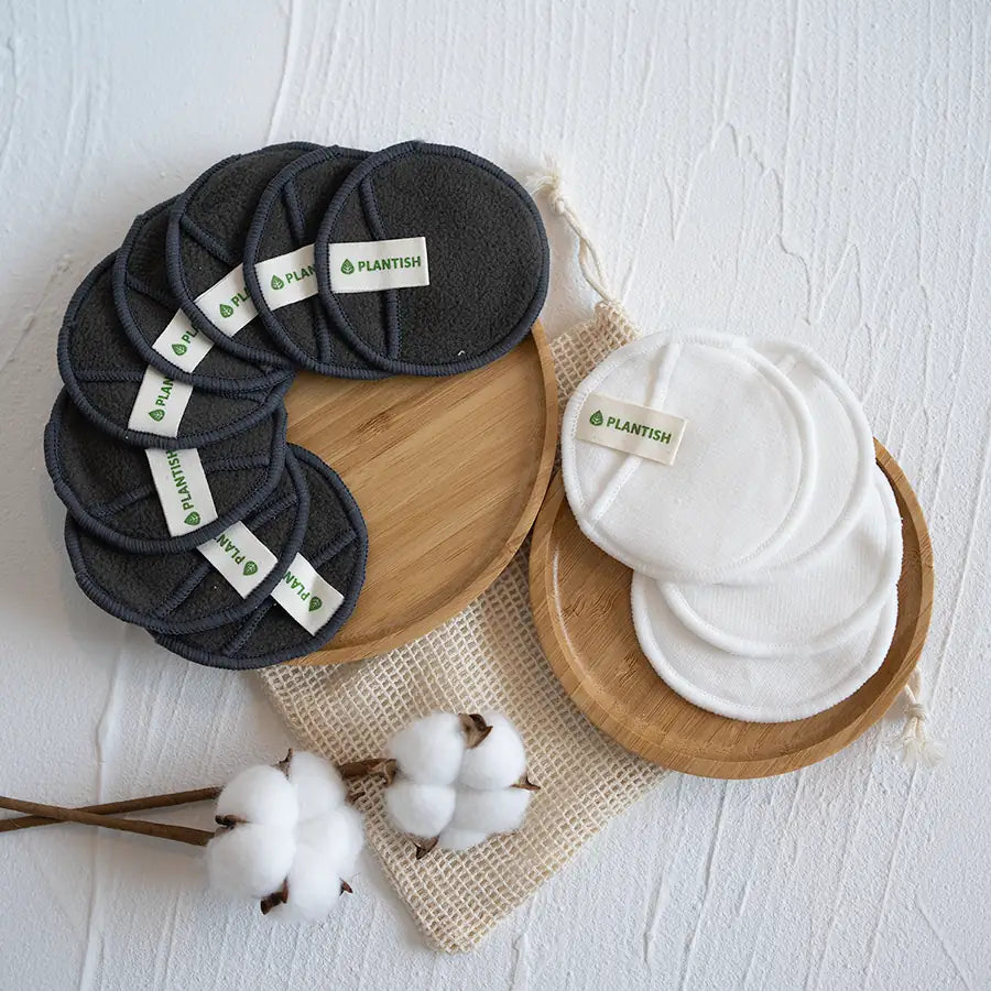 A set of reusable cotton rounds made from cotton and bamboo, displayed in an organic mesh bag, showcasing their eco-friendly design.