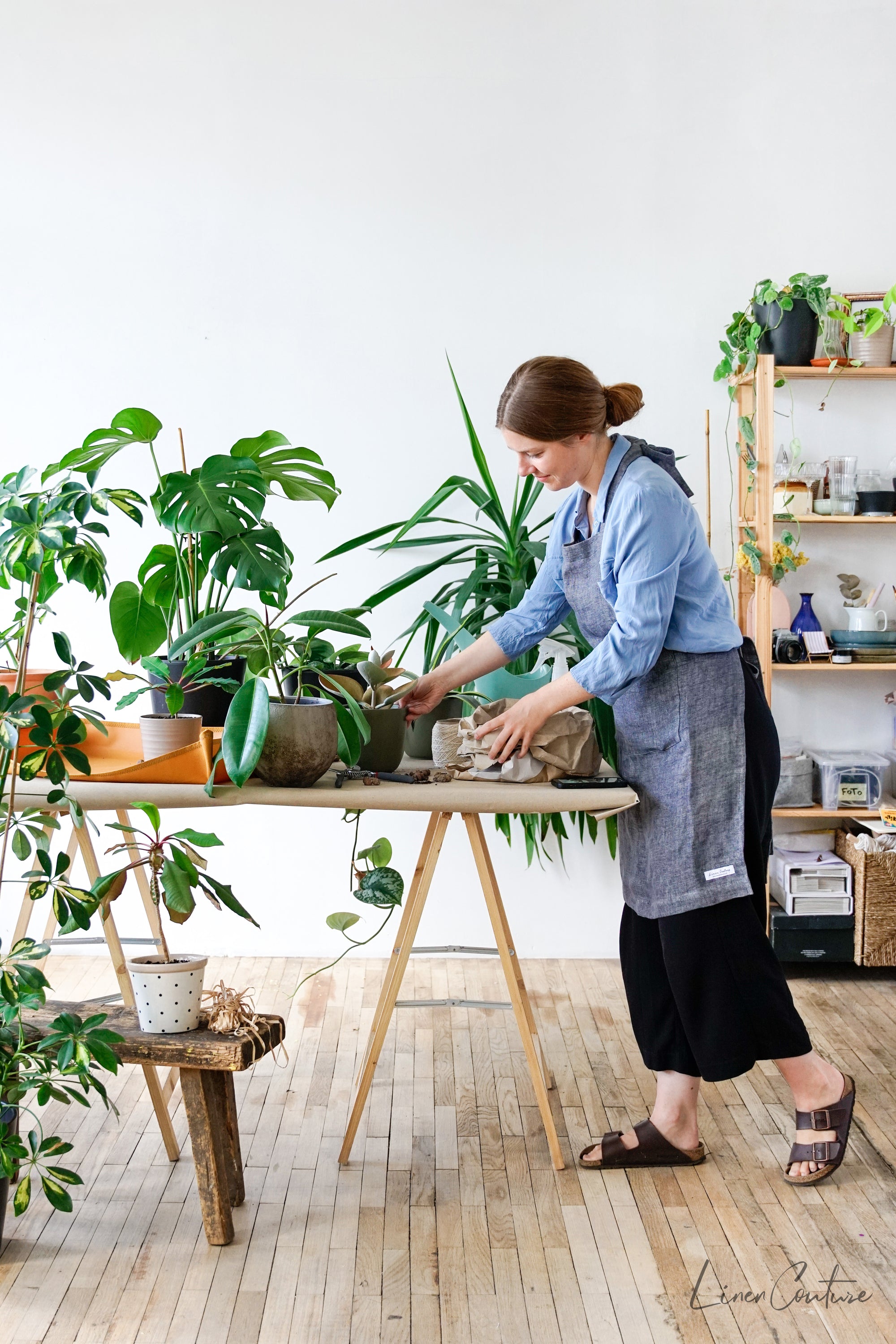 Reversible double cloth linen apron in grey and natural colors, featuring four pockets and back ties for adjustable fit.