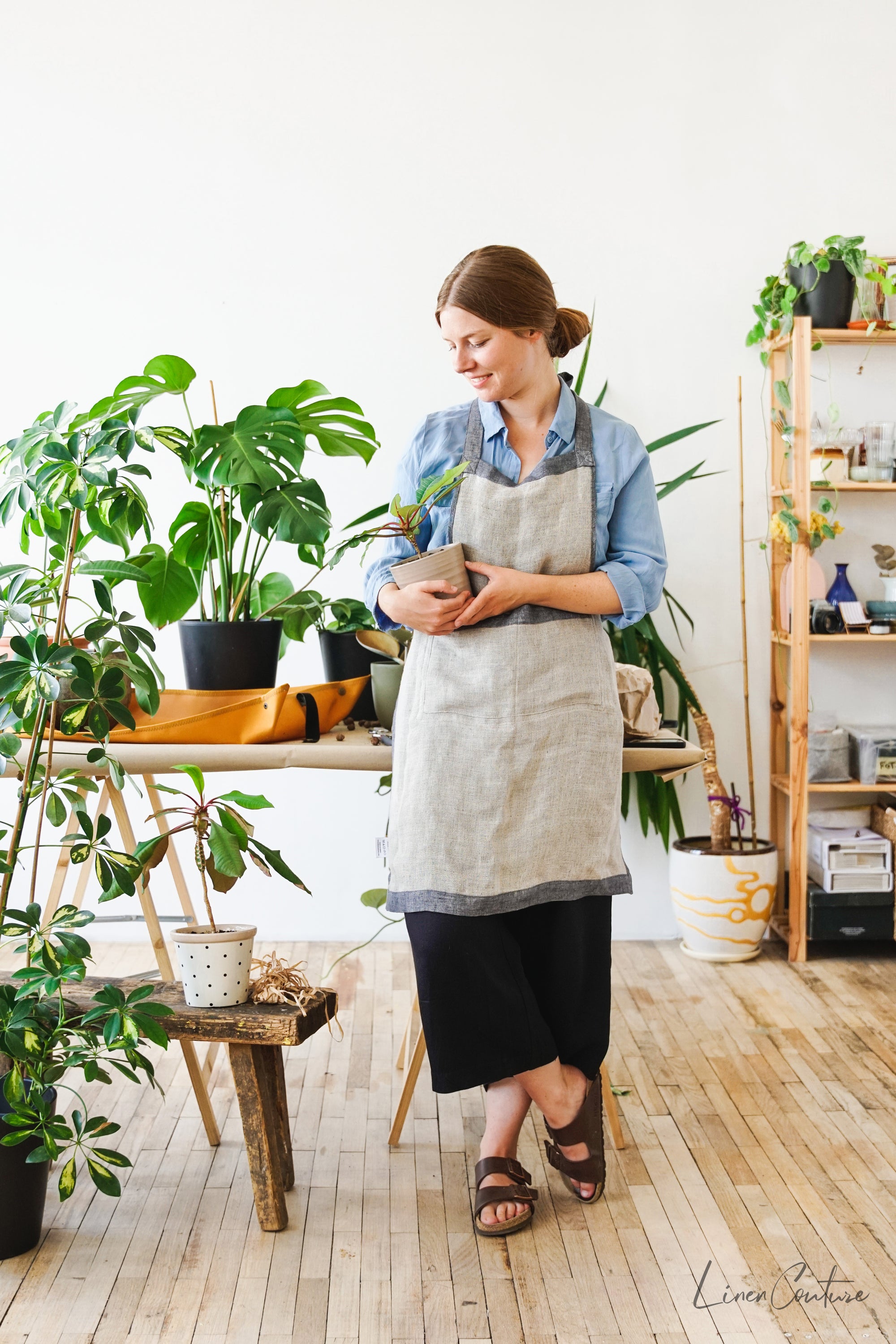 Reversible double cloth linen apron in grey and natural colors, featuring four pockets and back ties for adjustable fit.