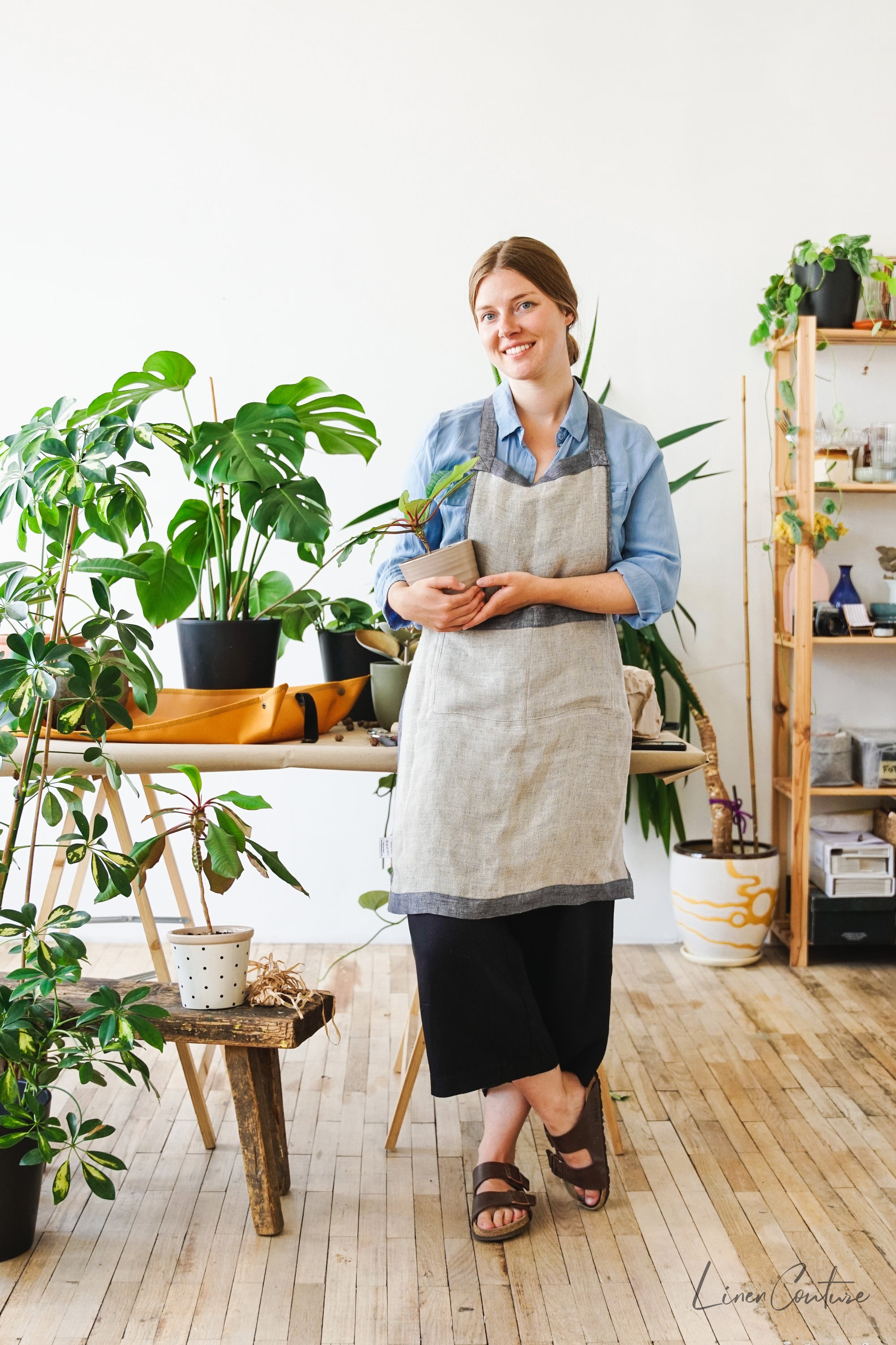 Reversible double cloth linen apron in grey and natural colors, featuring four pockets and back ties for adjustable fit.