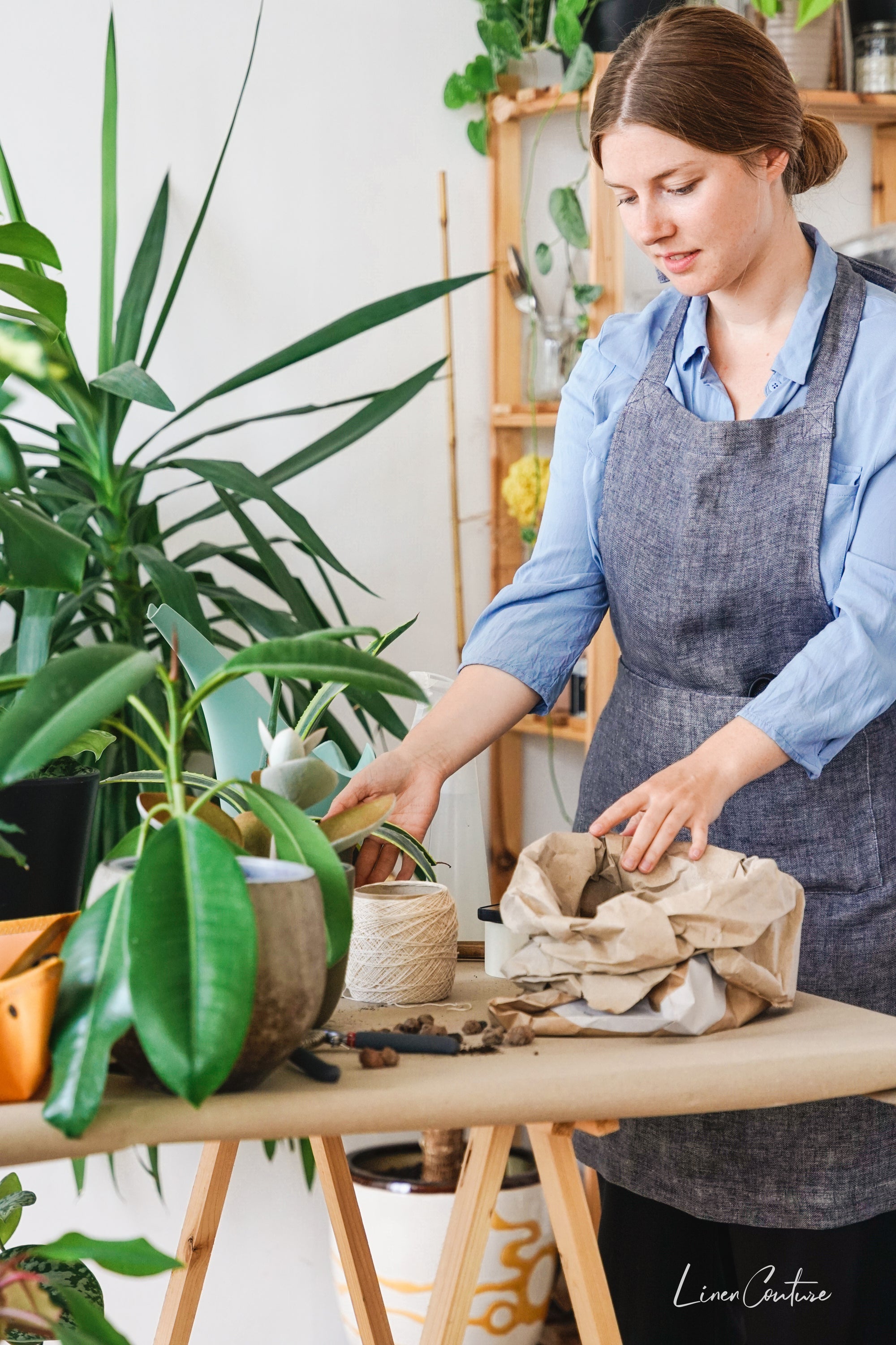 Reversible double cloth linen apron in grey and natural colors, featuring four pockets and back ties for adjustable fit.