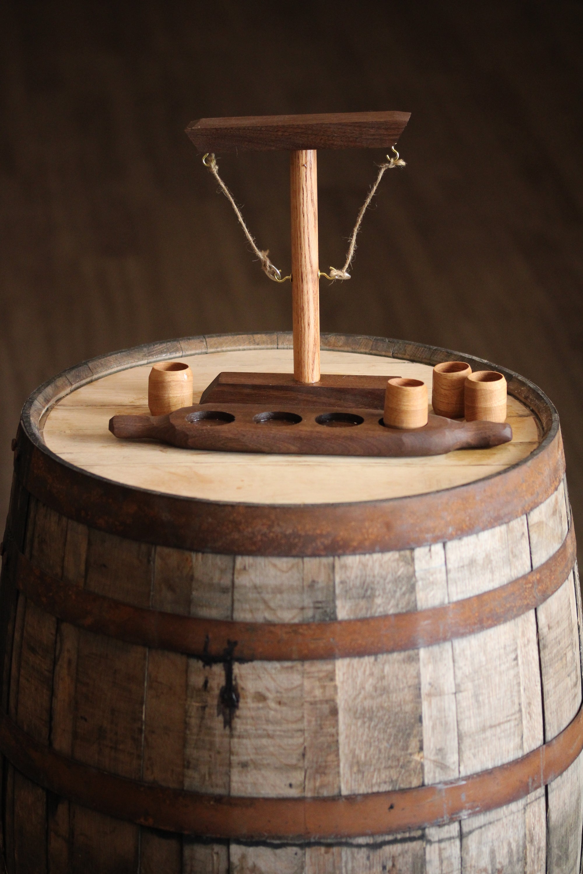 Ring Toss Game featuring a walnut and white oak stand with four shot cups, elegantly crafted for fun and sustainability.