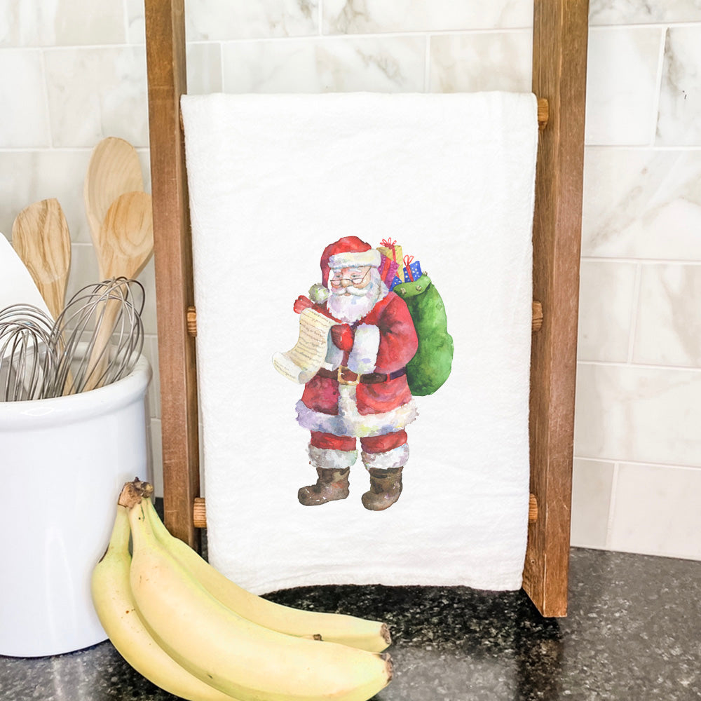 A festive cotton tea towel featuring Santa with a list, showcasing vibrant colors and hemmed edges, perfect for holiday kitchens.