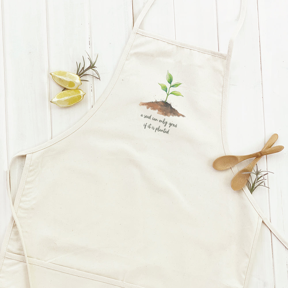 Seedling Quote Women's Apron featuring elegant design, adjustable neck, and divided front pocket, made from durable cotton canvas.