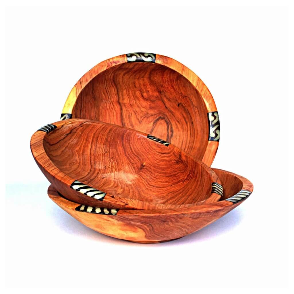 A beautifully handcrafted set of three African olive wood salad and fruit bowls, showcasing unique grain patterns and batik cow bone decoration.