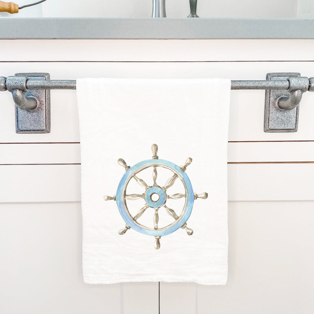 A vibrant cotton tea towel featuring a ship wheel design, perfect for kitchen use.