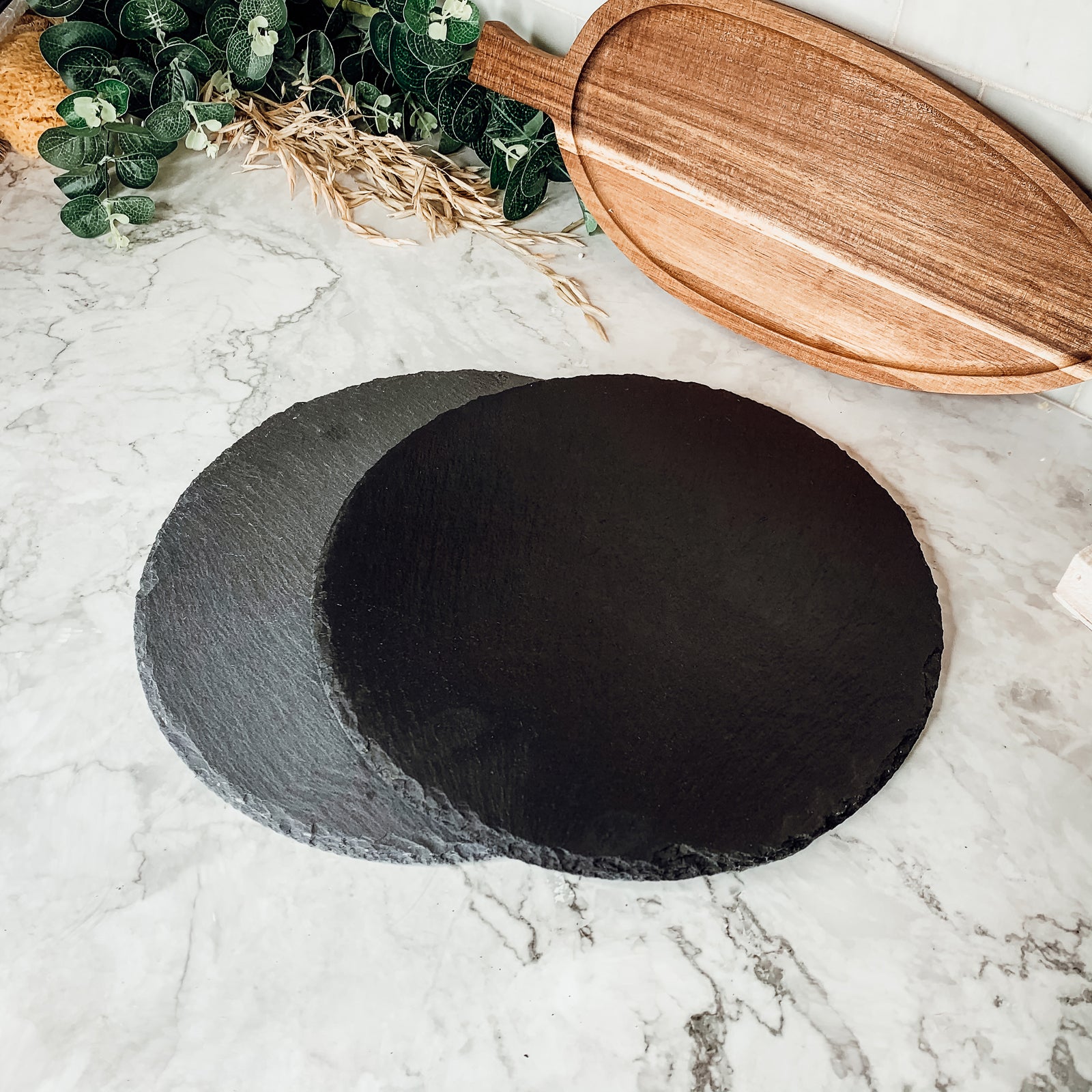 11-inch round slate cheese board with natural edges, perfect for serving appetizers and cheeses.