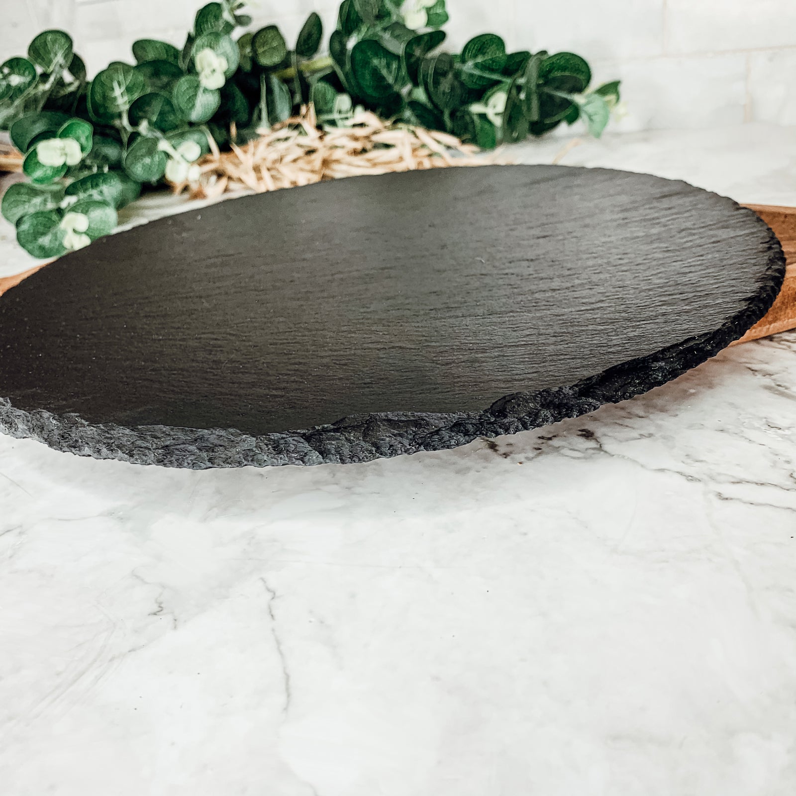 11-inch round slate cheese board with natural edges, perfect for serving appetizers and cheeses.