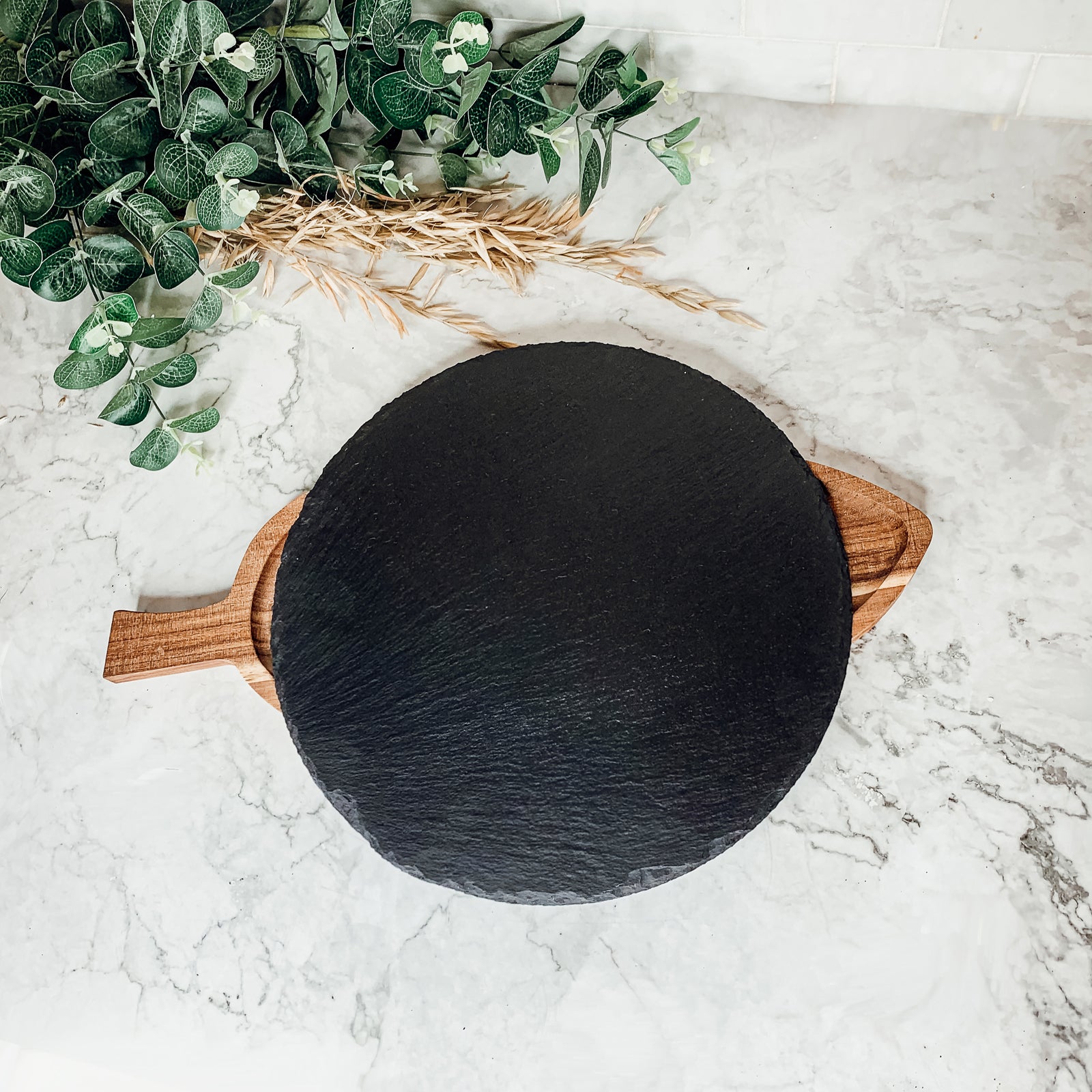 11-inch round slate cheese board with natural edges, perfect for serving appetizers and cheeses.