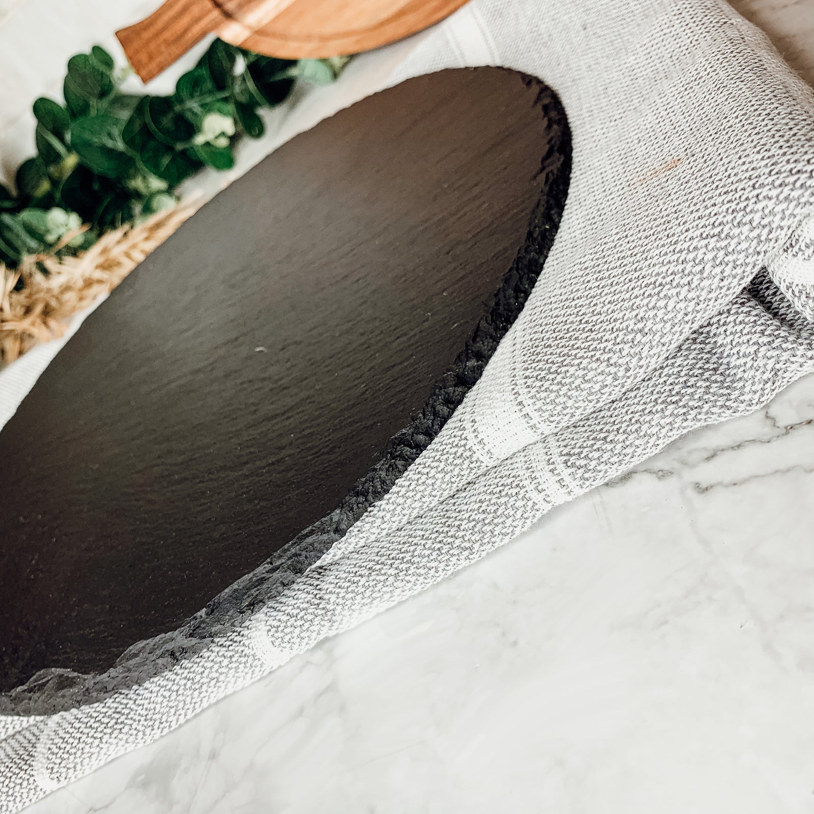 11-inch round slate cheese board with natural edges, perfect for serving appetizers and cheeses.