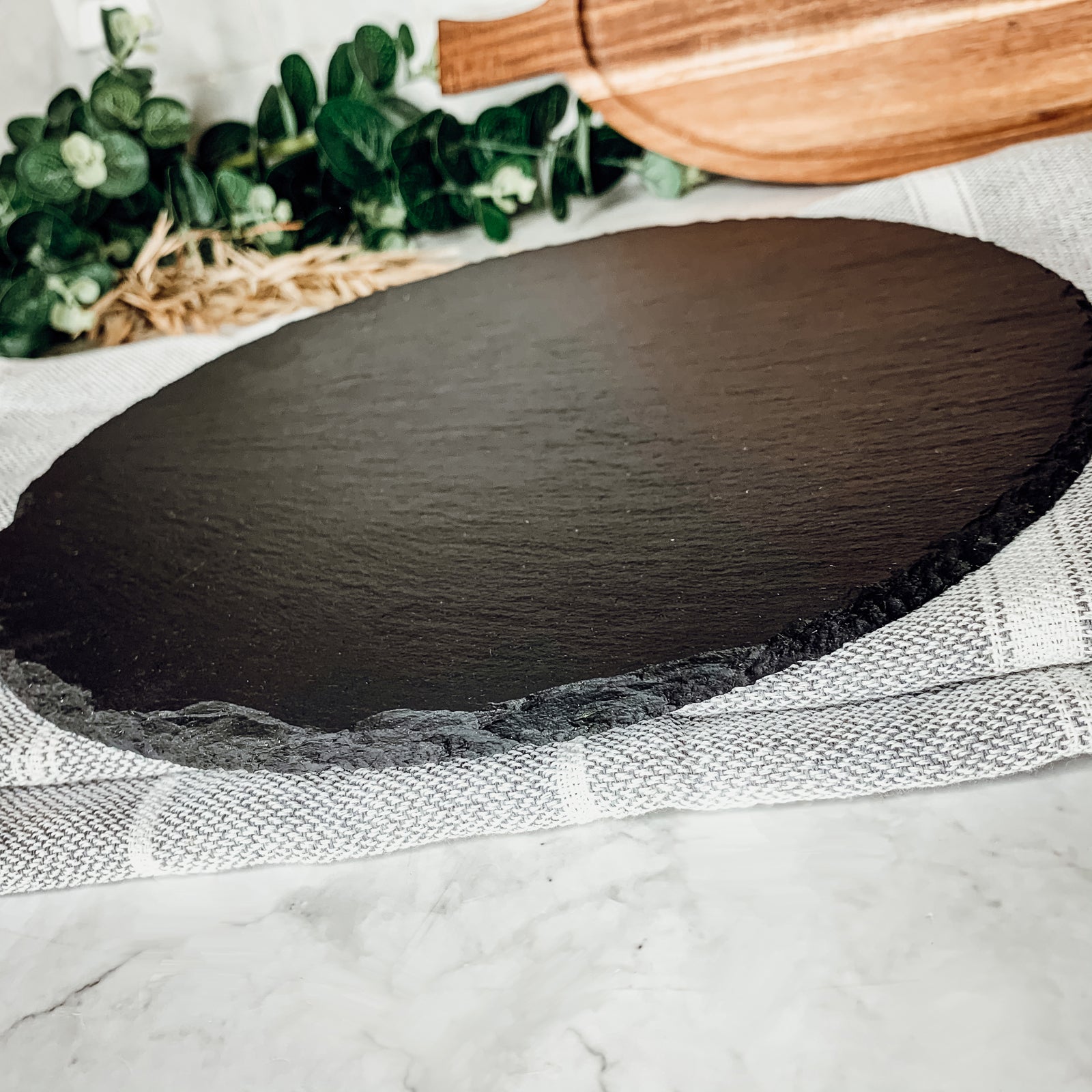 11-inch round slate cheese board with natural edges, perfect for serving appetizers and cheeses.