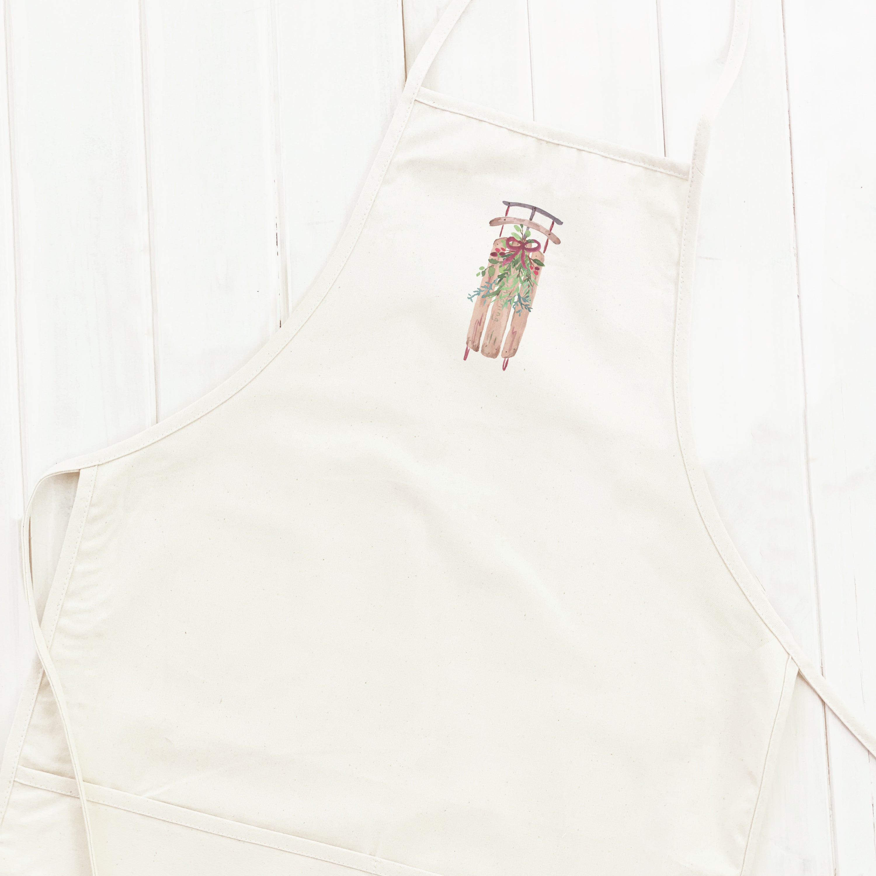 Sled with Mistletoe Women's Apron featuring elegant design and divided front pocket, made from durable cotton canvas.