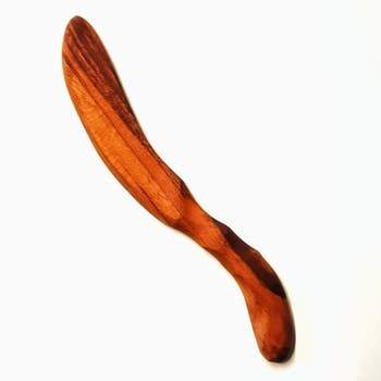 A sleek Soft Cheese Spreader with a curved handle and beveled edges, crafted from Cherry wood, designed for easy cheese spreading.