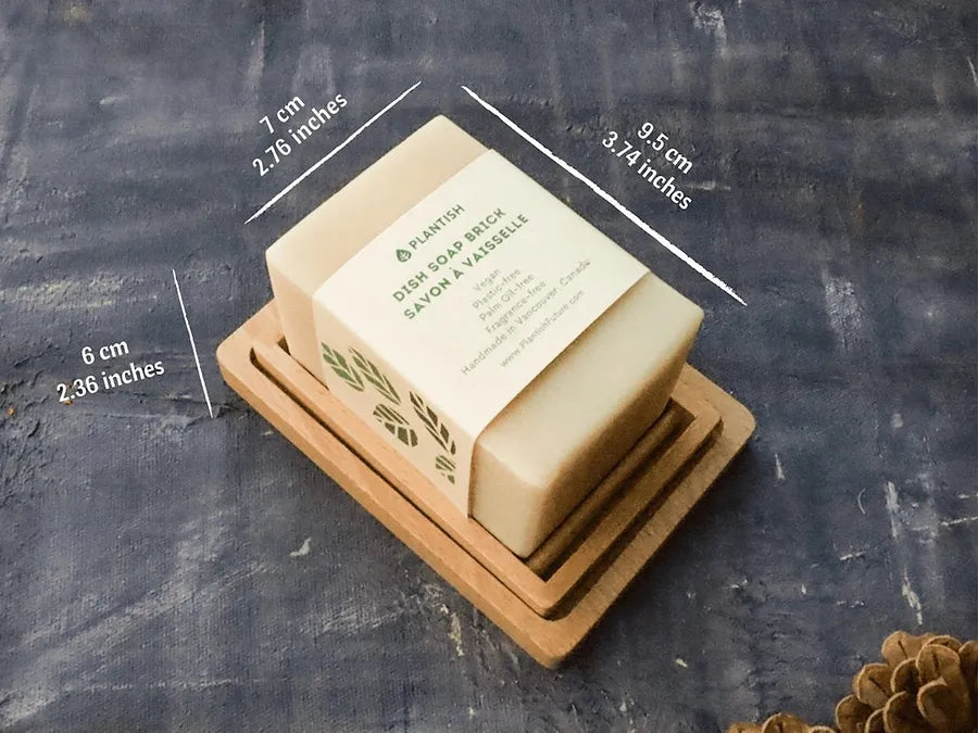 Solid Dish Soap Brick (13oz) displayed on a bamboo soap dish, showcasing its eco-friendly packaging and natural ingredients.