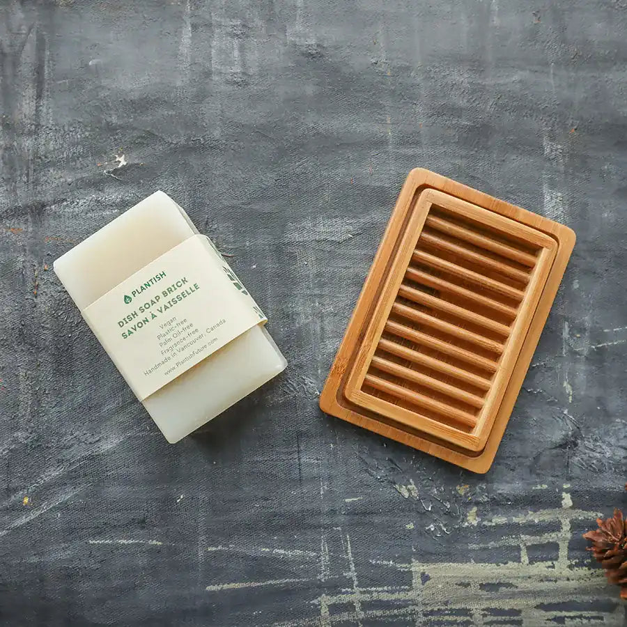 Solid Dish Soap Brick (13oz) displayed on a bamboo soap dish, showcasing its eco-friendly packaging and natural ingredients.