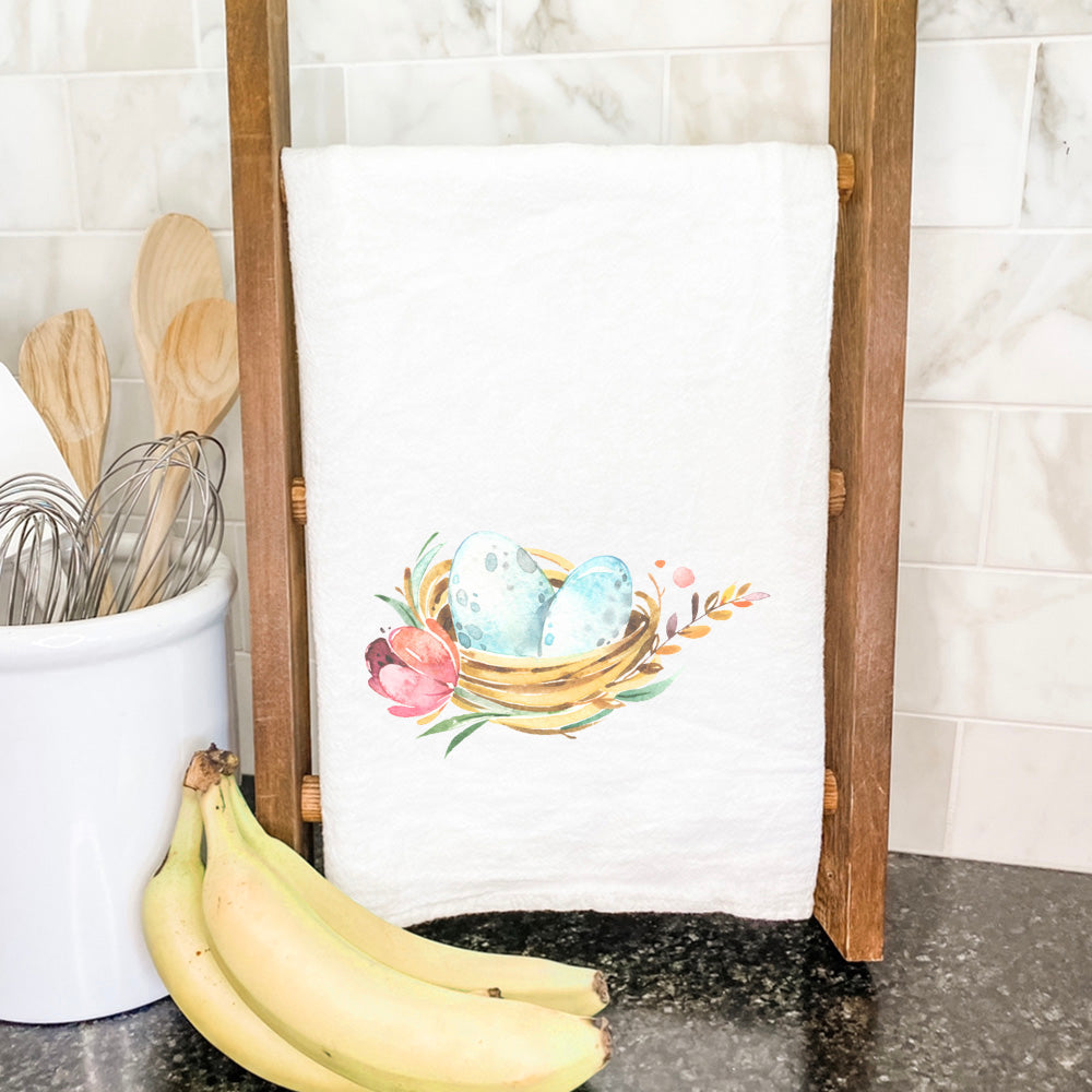 A vibrant cotton tea towel featuring a Spring Birds Nest design, perfect for kitchen use.