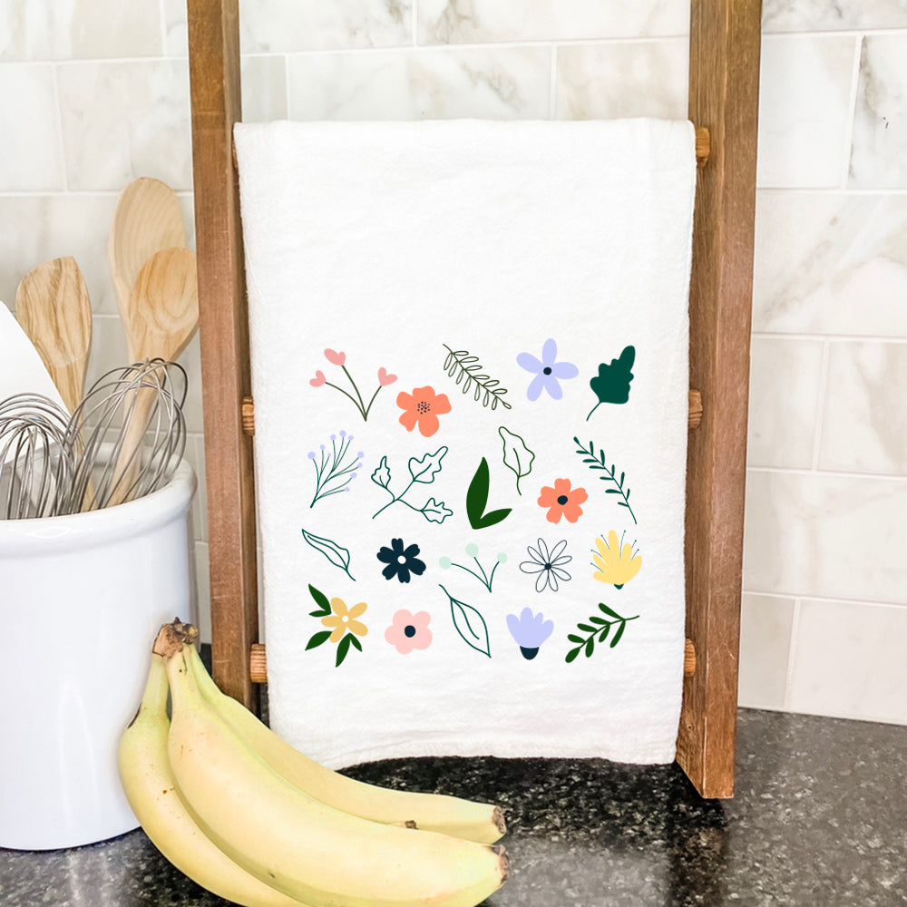 A vibrant Spring Sprigs Cotton Tea Towel featuring a beautiful floral design, made from 100% absorbent cotton, displayed on a kitchen countertop.