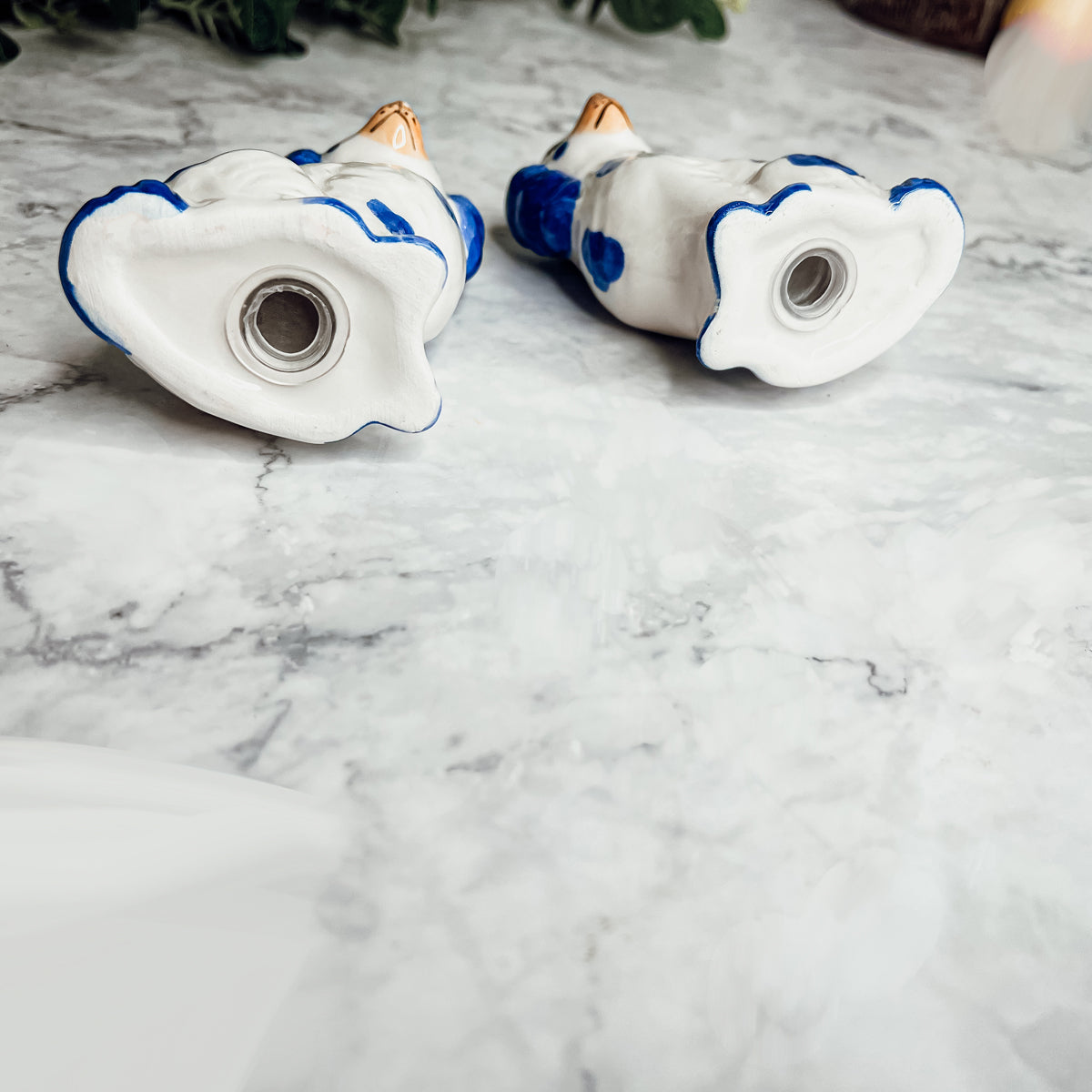 Hand-painted Staffordshire dog salt and pepper shakers in blue and white ceramic, showcasing intricate details and a high glaze finish.