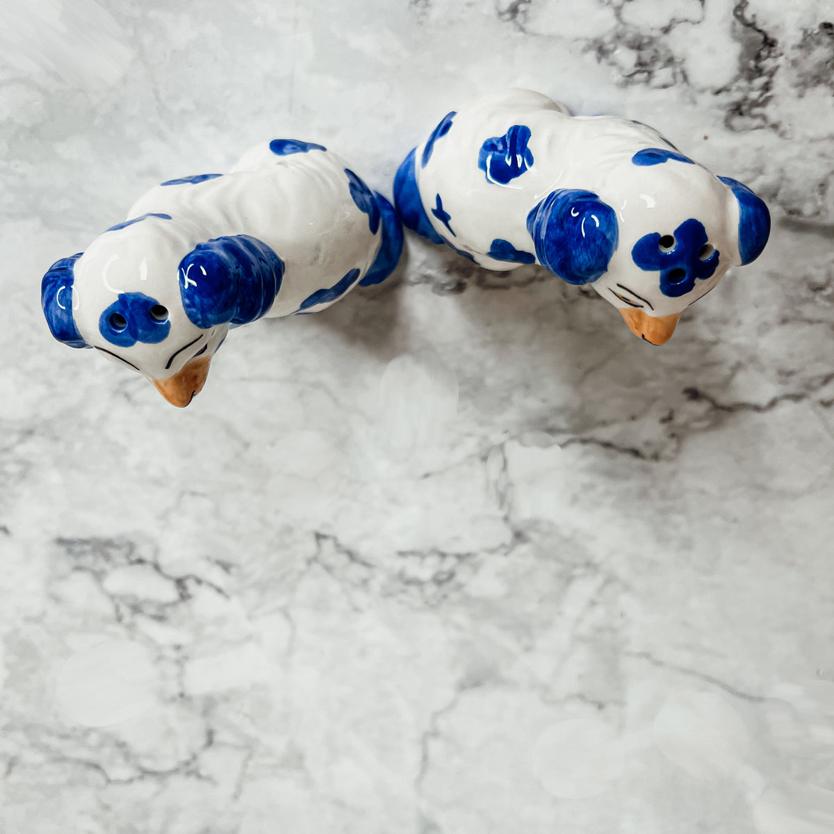 Hand-painted Staffordshire dog salt and pepper shakers in blue and white ceramic, showcasing intricate details and a high glaze finish.