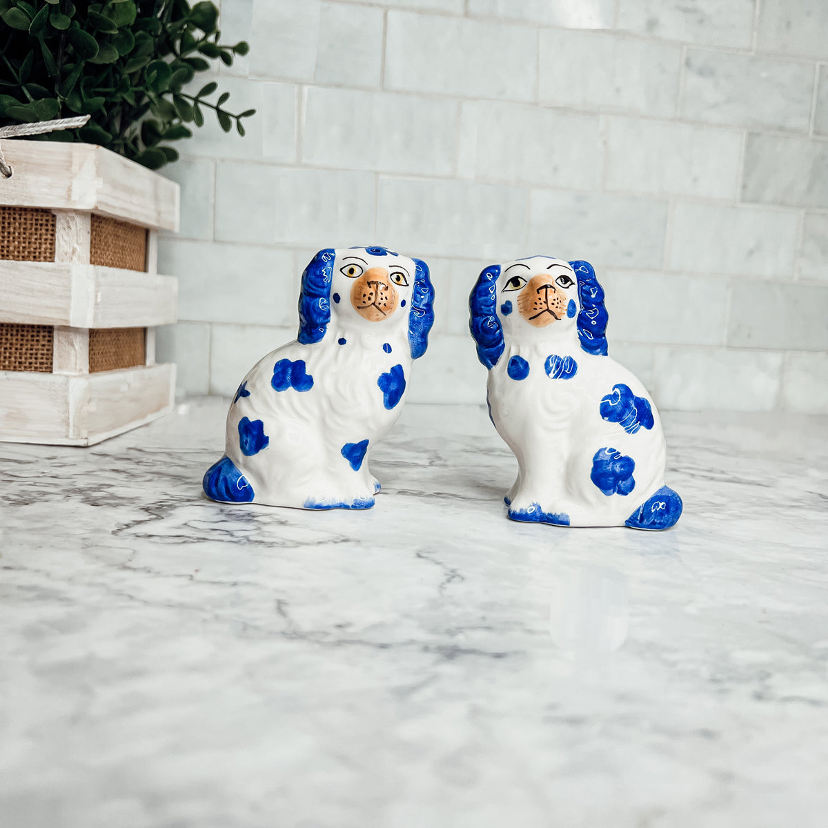 Hand-painted Staffordshire dog salt and pepper shakers in blue and white ceramic, showcasing intricate details and a high glaze finish.