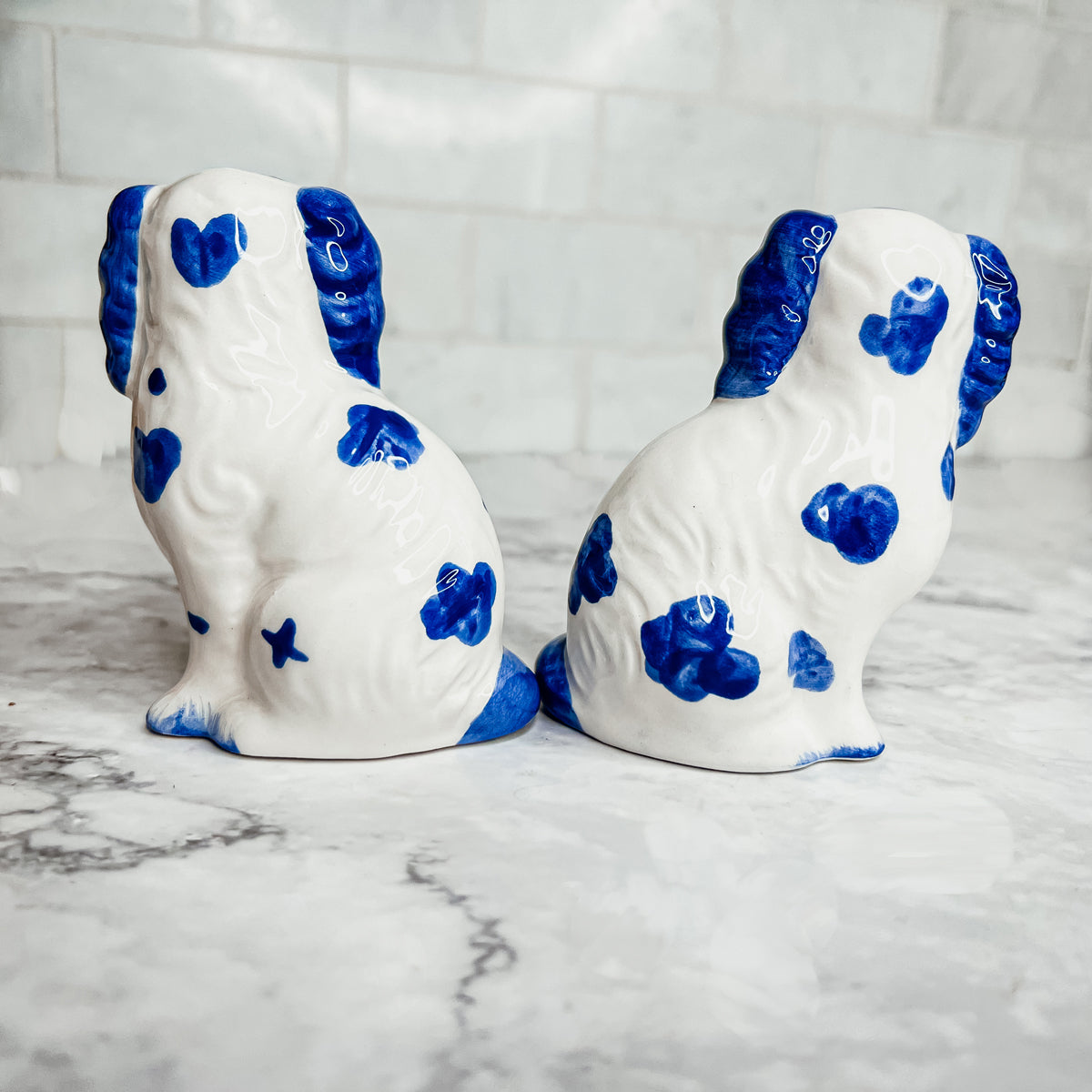 Hand-painted Staffordshire dog salt and pepper shakers in blue and white ceramic, showcasing intricate details and a high glaze finish.