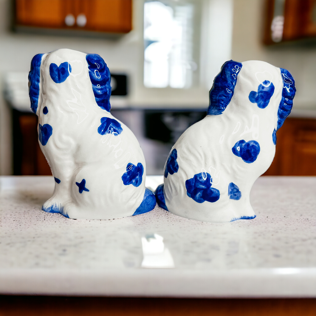 Hand-painted Staffordshire dog salt and pepper shakers in blue and white ceramic, showcasing intricate details and a high glaze finish.