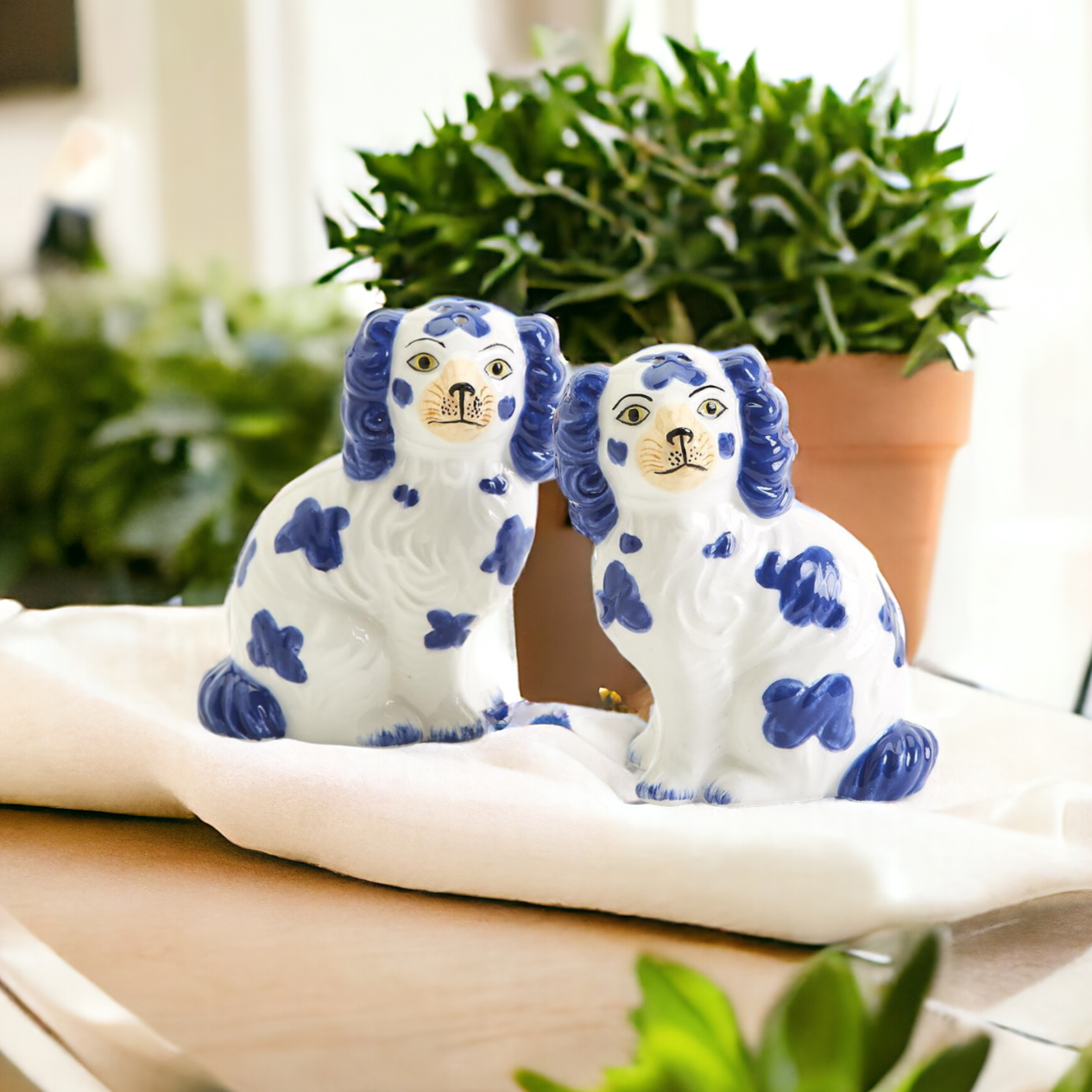 Hand-painted Staffordshire dog salt and pepper shakers in blue and white ceramic, showcasing intricate details and a high glaze finish.