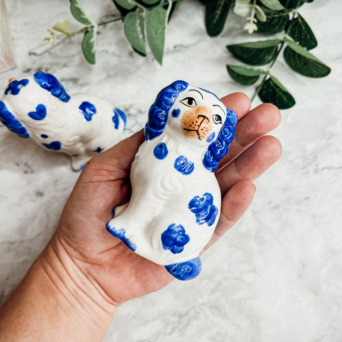 Hand-painted Staffordshire dog salt and pepper shakers in blue and white ceramic, showcasing intricate details and a high glaze finish.