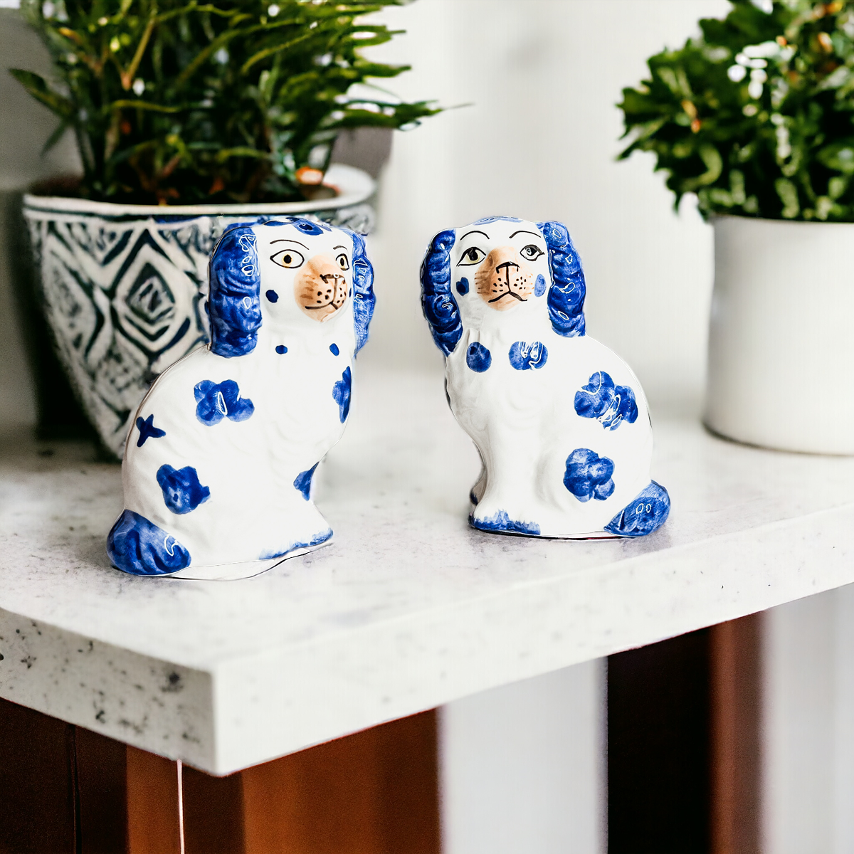 Hand-painted Staffordshire dog salt and pepper shakers in blue and white ceramic, showcasing intricate details and a high glaze finish.