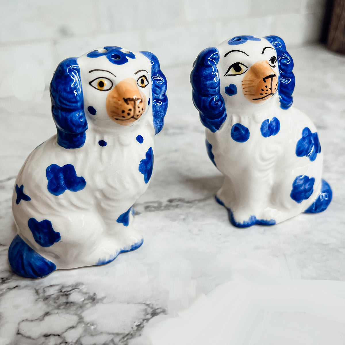 Hand-painted Staffordshire dog salt and pepper shakers in blue and white ceramic, showcasing intricate details and a high glaze finish.