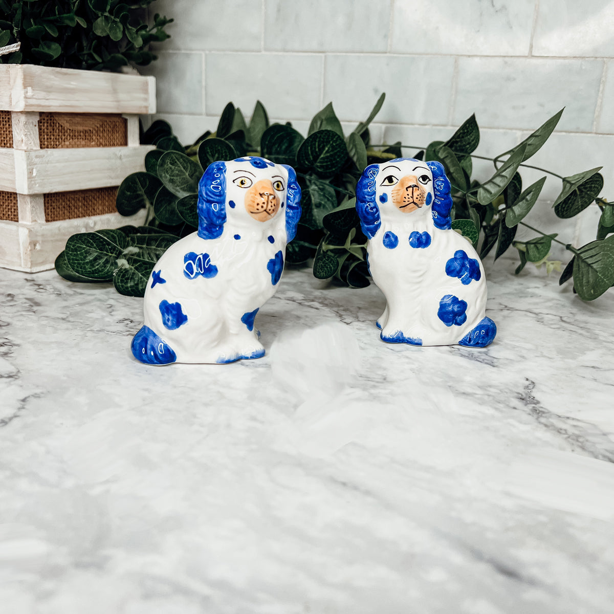 Hand-painted Staffordshire dog salt and pepper shakers in blue and white ceramic, showcasing intricate details and a high glaze finish.